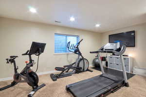 Carpeted room with recessed lighting and a single window featuring horizontal blinds