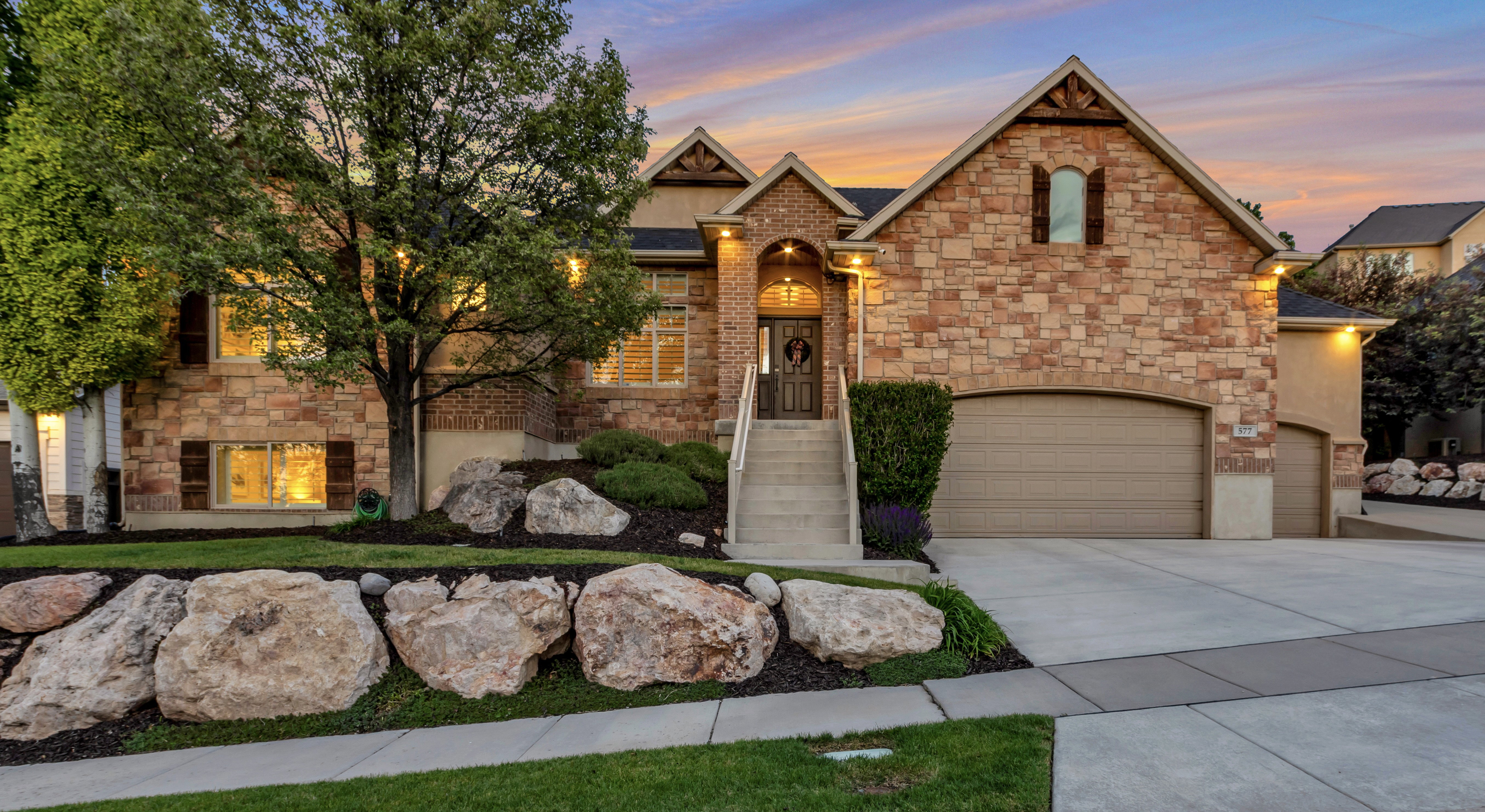 Stunning custom home with timeless stone architecture, manicured landscaping, and exceptional curb appeal in one of the area's premier luxury neighborhoods.