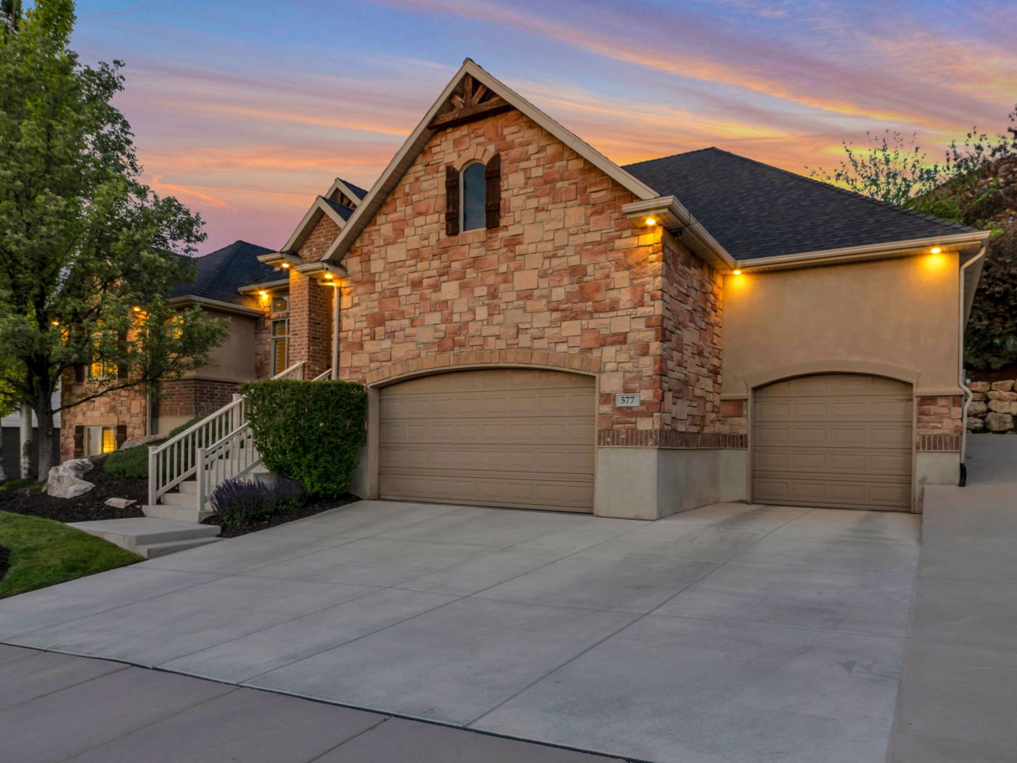 Elegant front elevation featuring mature landscaping, custom stonework, and a welcoming approach.