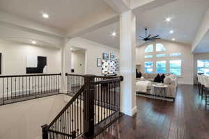 Open-concept living space featuring wood-finish flooring, a vaulted ceiling, and recessed lighting