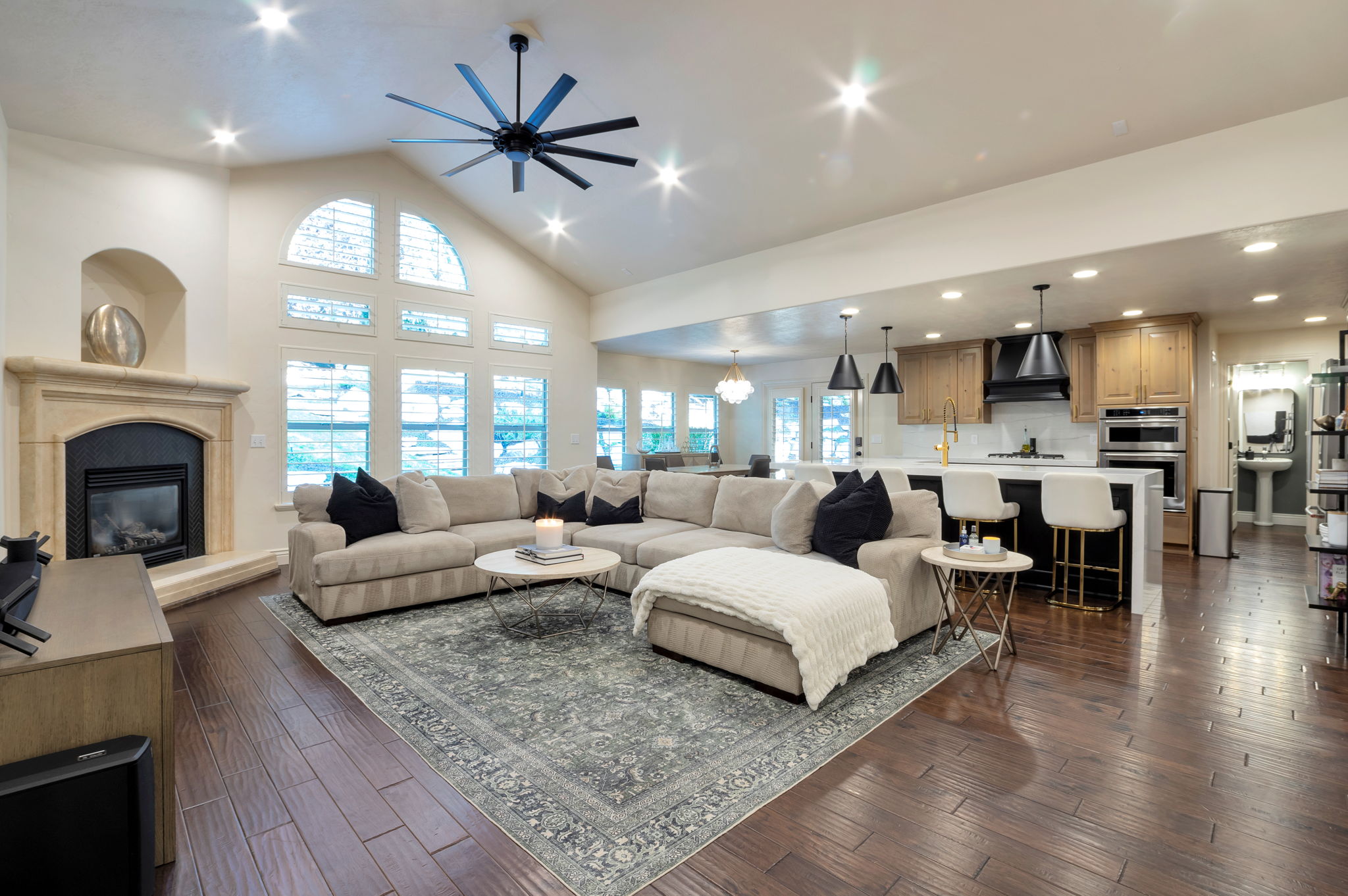 Expansive gathering space highlighted by soaring ceilings, hardwood floors, and beautiful views of the surrounding mature landscape.