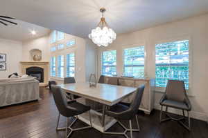 Open-concept dining area featuring dark wood-finish flooring and a contemporary chandelier