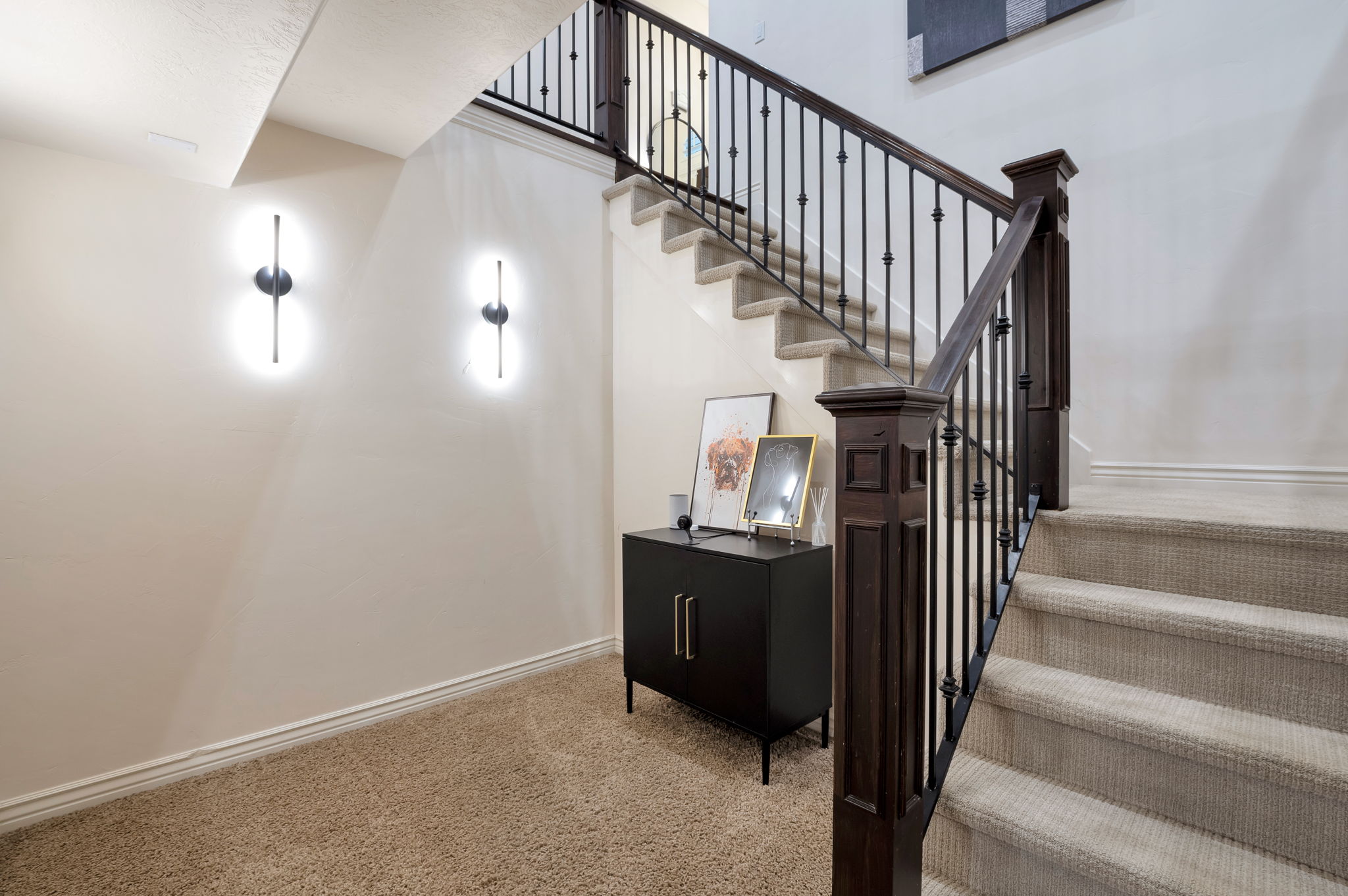 Custom staircase with wrought iron railing leading to the expansive lower level.