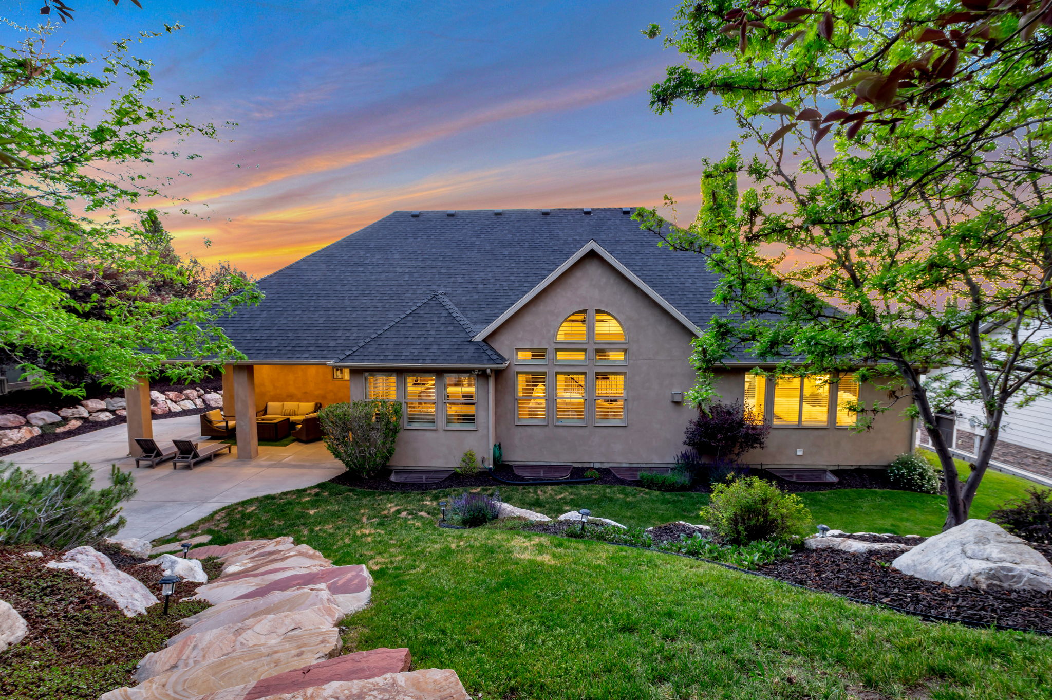 Park-like backyard with lush lawn, extensive landscaping, towering shade trees, and exceptional privacy.