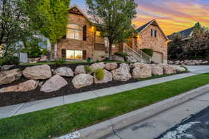 Stone-clad exterior featuring multiple gables, arched windows, and a two-car garage