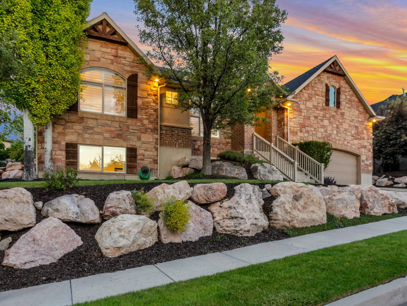 Beautiful evening curb appeal showcases the home's timeless architecture and professionally landscaped grounds.