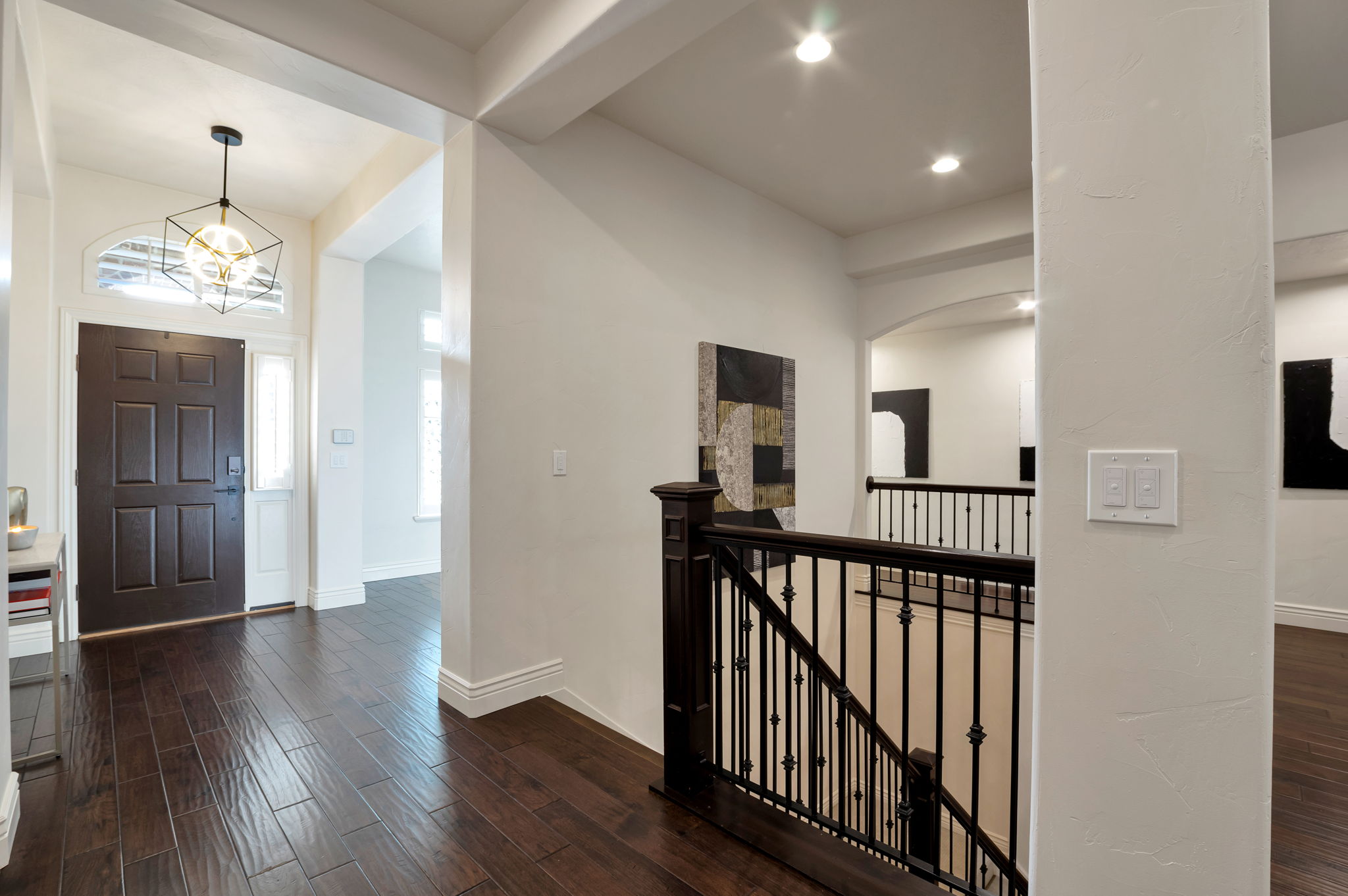 Open foyer showcasing the home's impressive ceiling height, quality finishes, and elegant staircase.