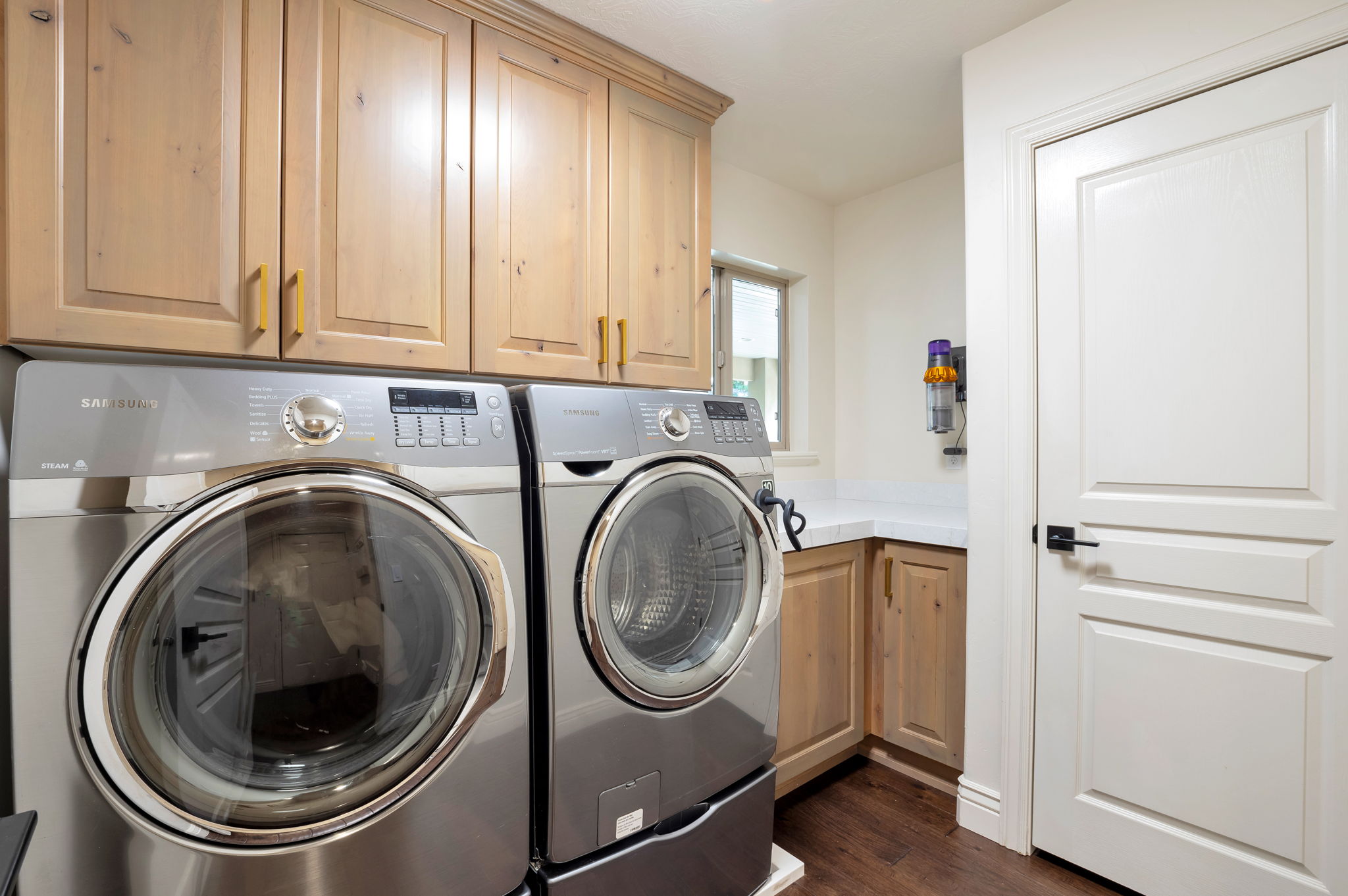 Well-appointed laundry room with extensive cabinetry, countertop workspace, and additional storage.