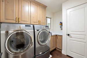 Laundry room featuring wood-finish flooring, light wood cabinetry, a built-in counter, and a window