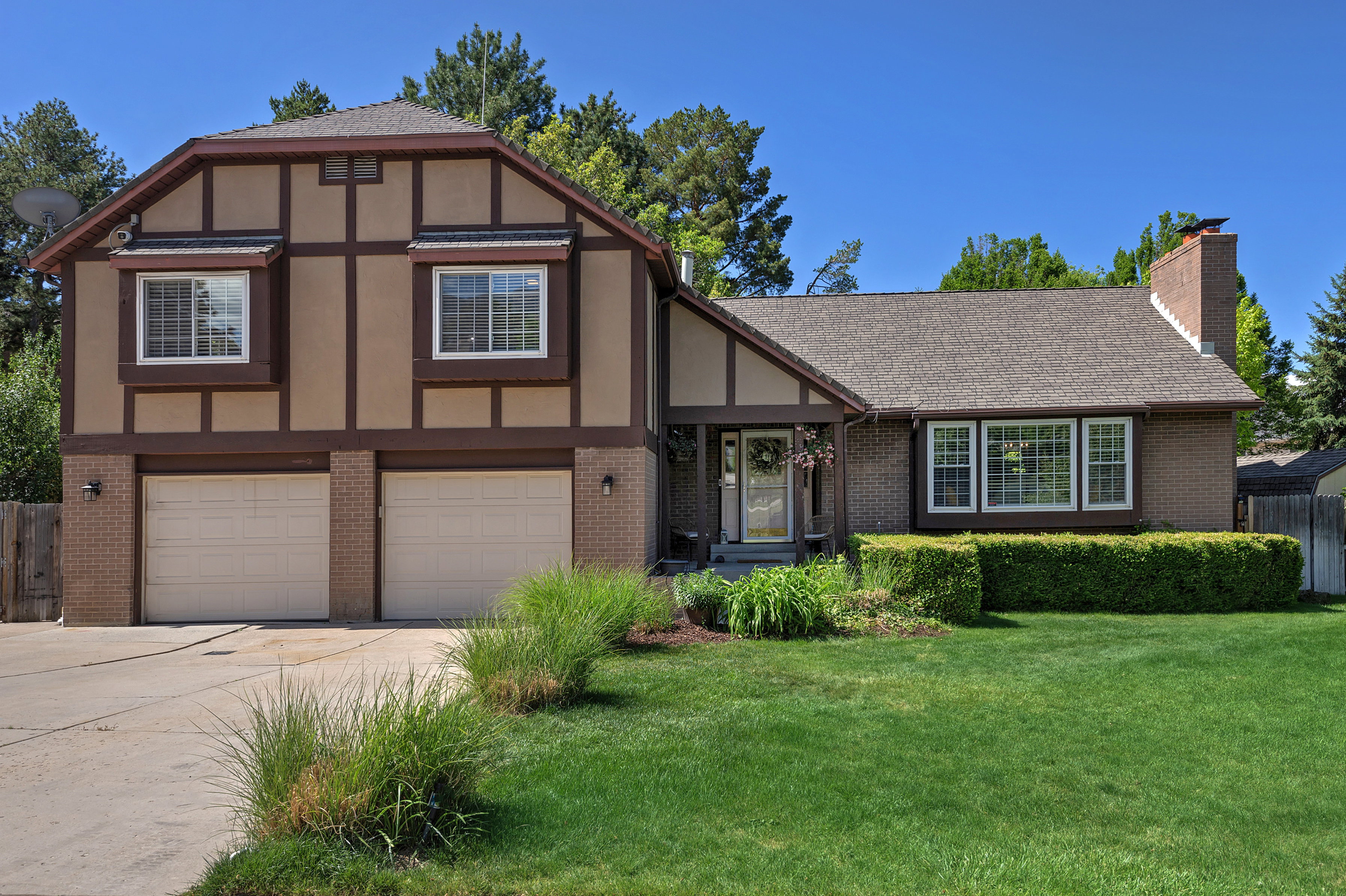 Traditional two-story exterior featuring brick and stucco siding with decorative timber detailing
