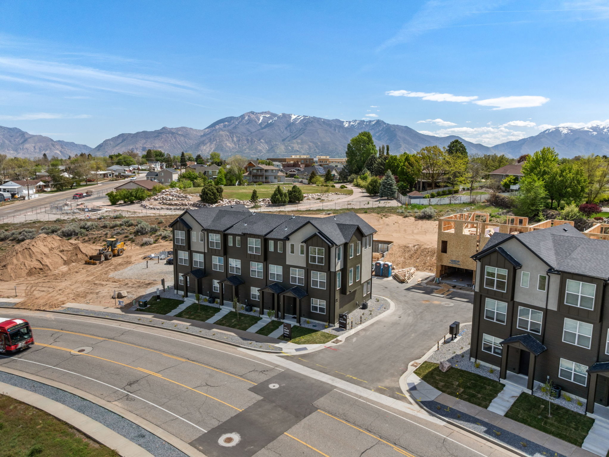 Modern townhouse development featuring dark siding with light grey accents and white trim windows