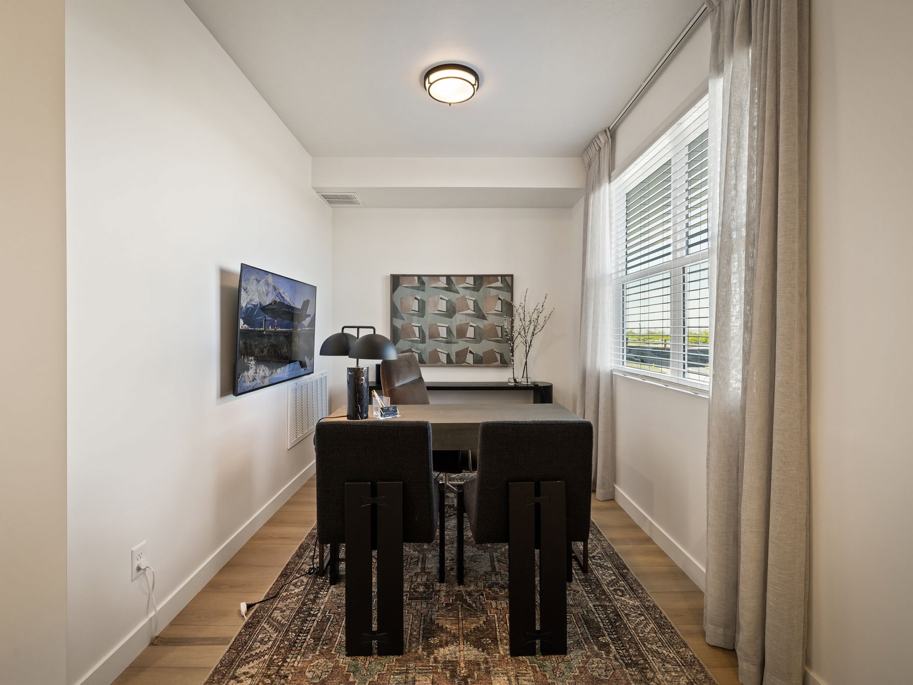 Bright room featuring wood-finish flooring, a large window with blinds, and recessed lighting