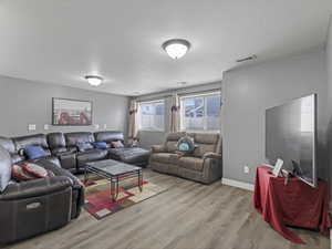 Spacious living area featuring wood-finish flooring and neutral wall tones