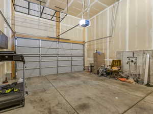 Spacious garage featuring a concrete floor, an overhead garage door, and ample wall space