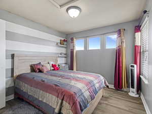 Room featuring three upper windows, wood-finish flooring, and a flush mount ceiling light