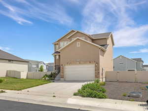 Stucco exterior with stone accenting and an attached two-car garage