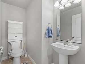 Pedestal sink with chrome faucet, large vanity mirror, and three-light fixture