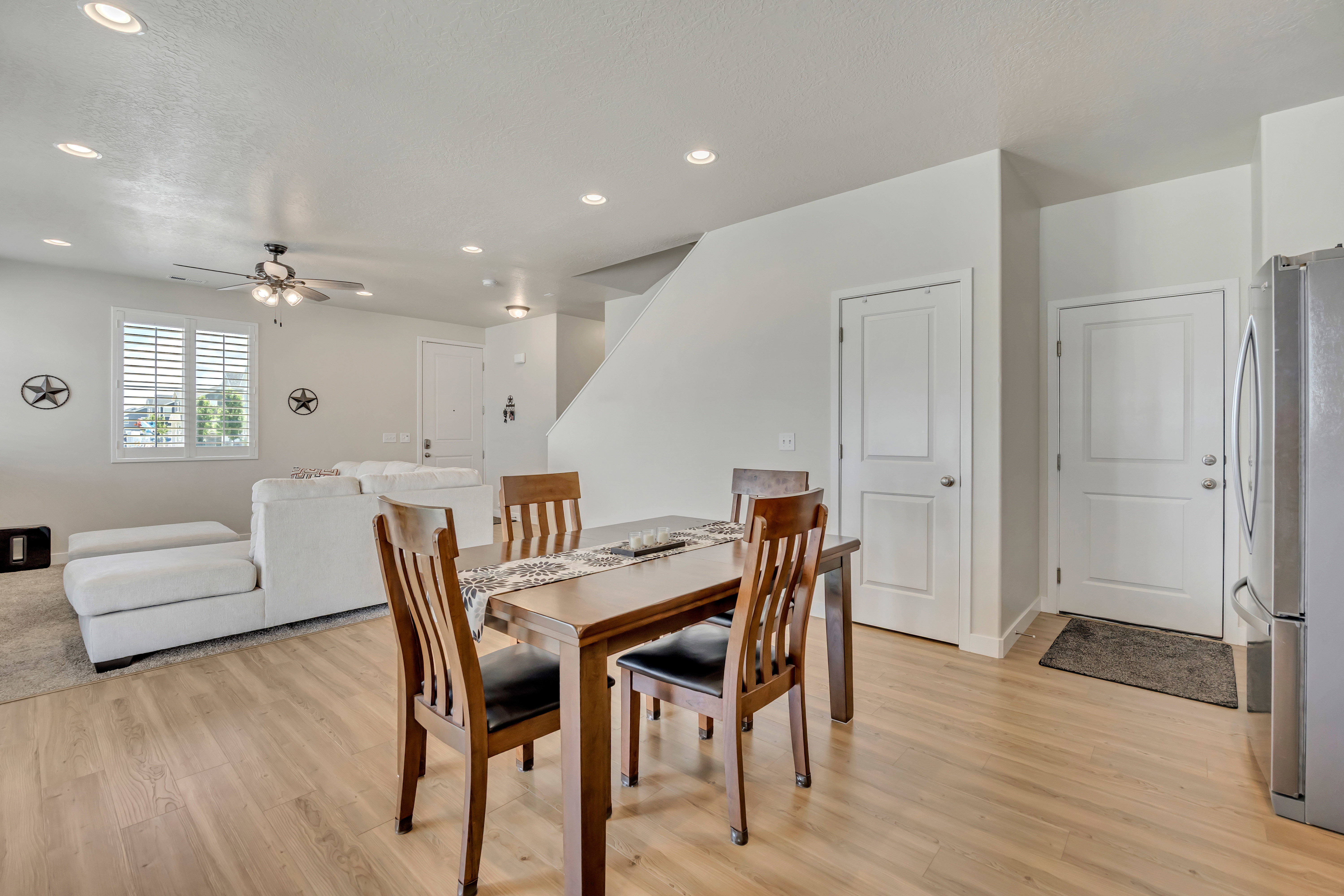 Open-concept living space with wood-finish flooring extending into the dining area