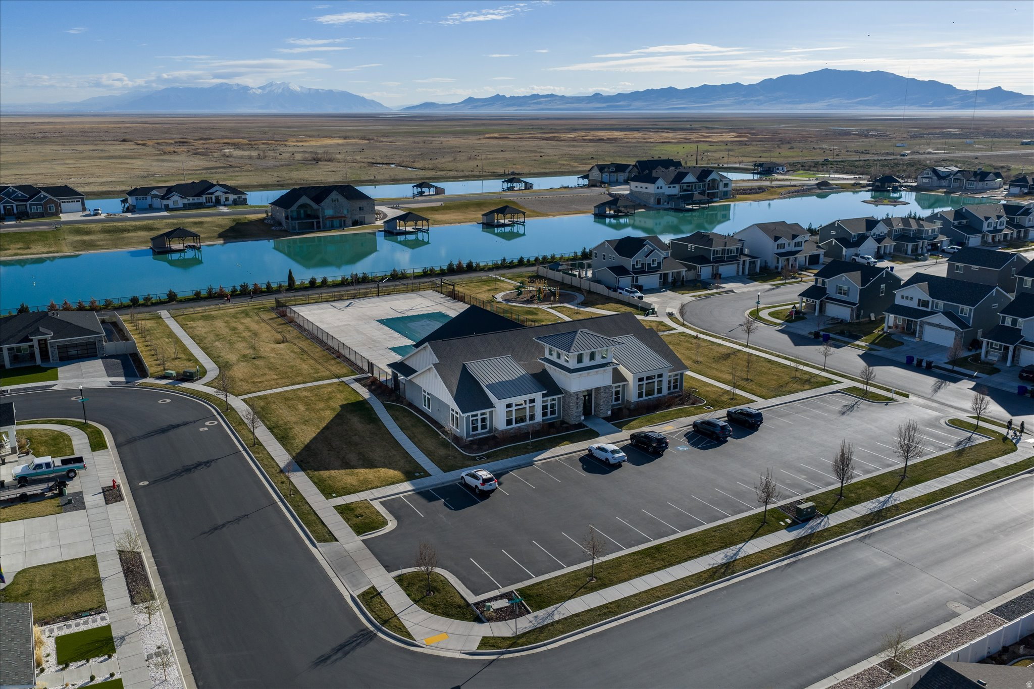 Aerial community perspective featuring a central clubhouse with an outdoor swimming pool and surrounding residential properties