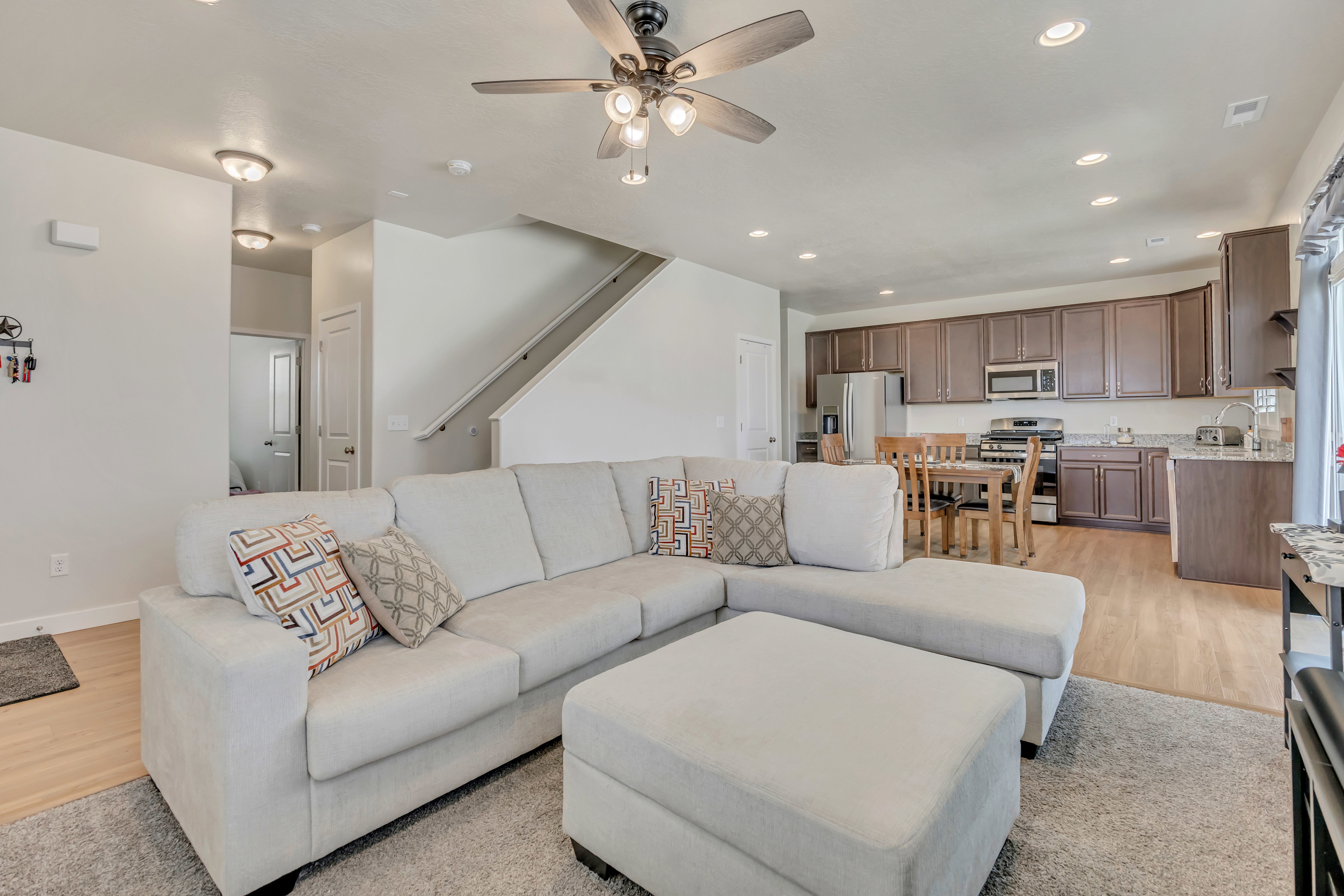 Open-concept living area featuring wood-finish flooring, recessed lighting, and a ceiling fan