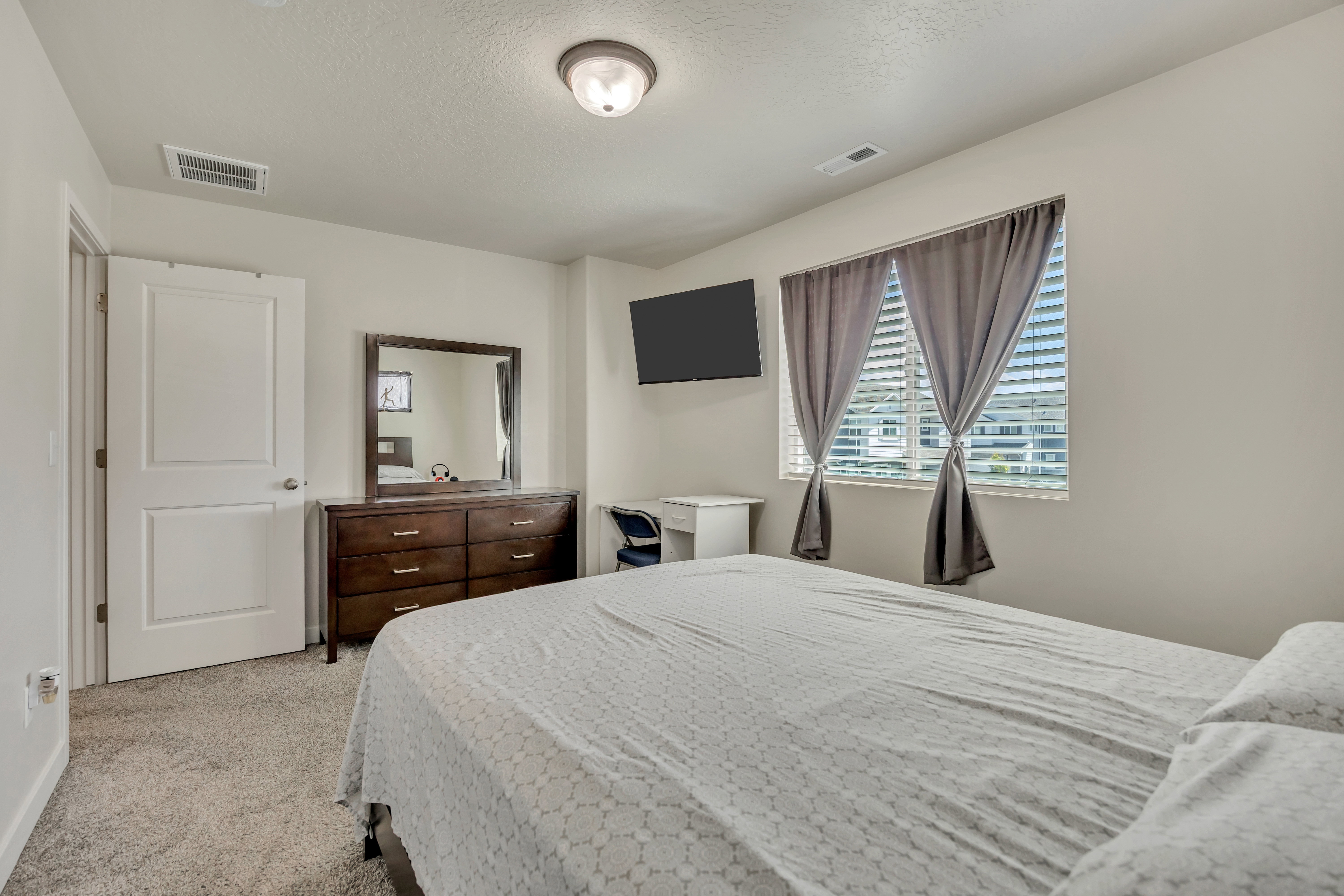 Neutral toned room featuring plush carpeting and a flush-mount ceiling light
