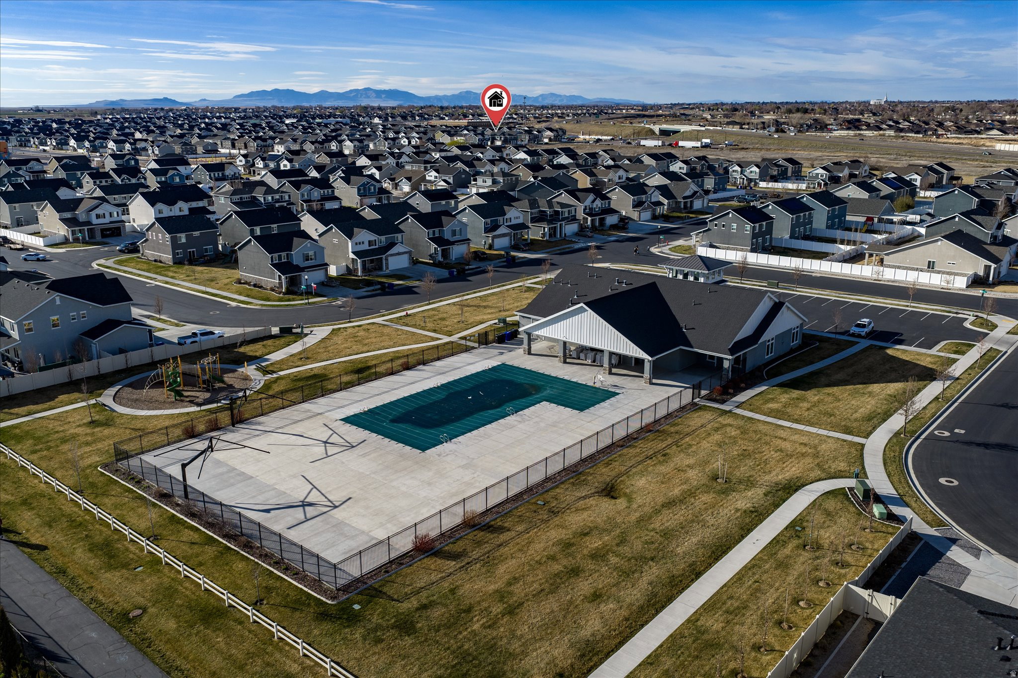 Community recreation area featuring a covered pool, clubhouse building, and playground