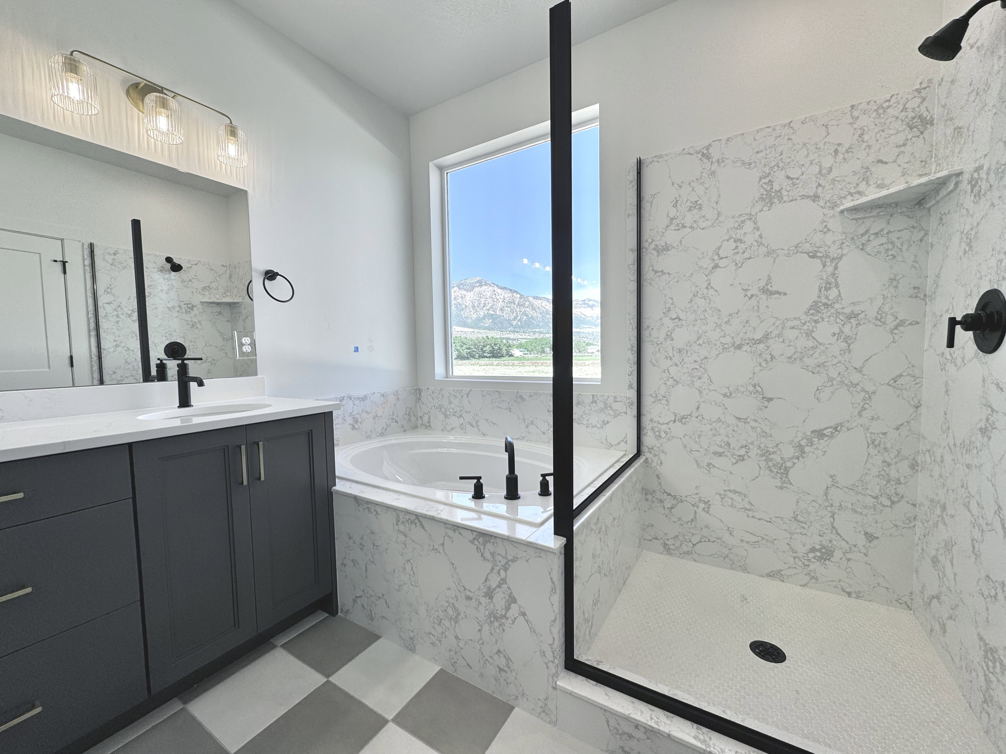 Contemporary bathroom featuring a built-in tub, a walk-in shower with patterned tile surround, and a vanity with a quartz countertop