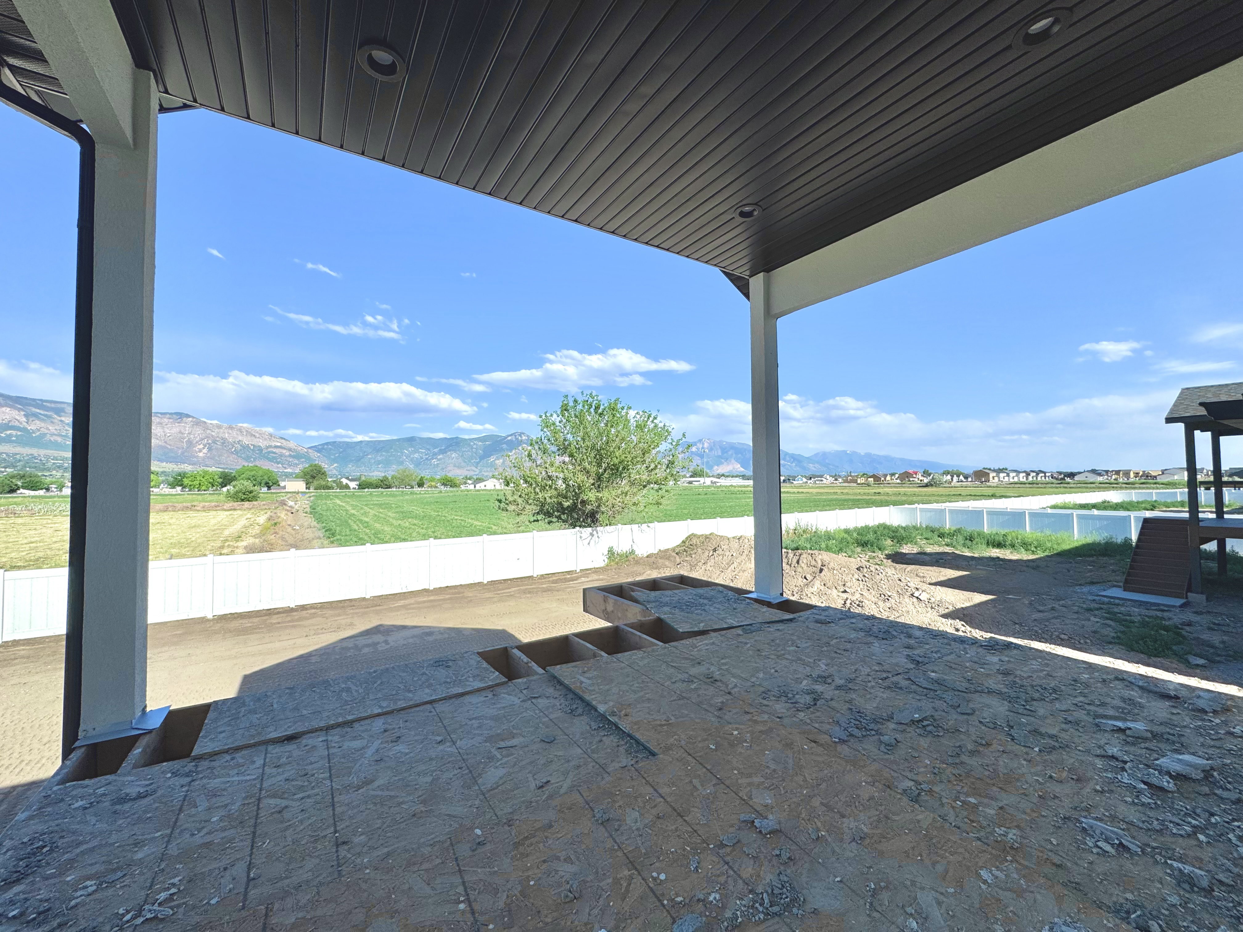 Covered patio space with recessed lighting, offering expansive mountain and field scenery