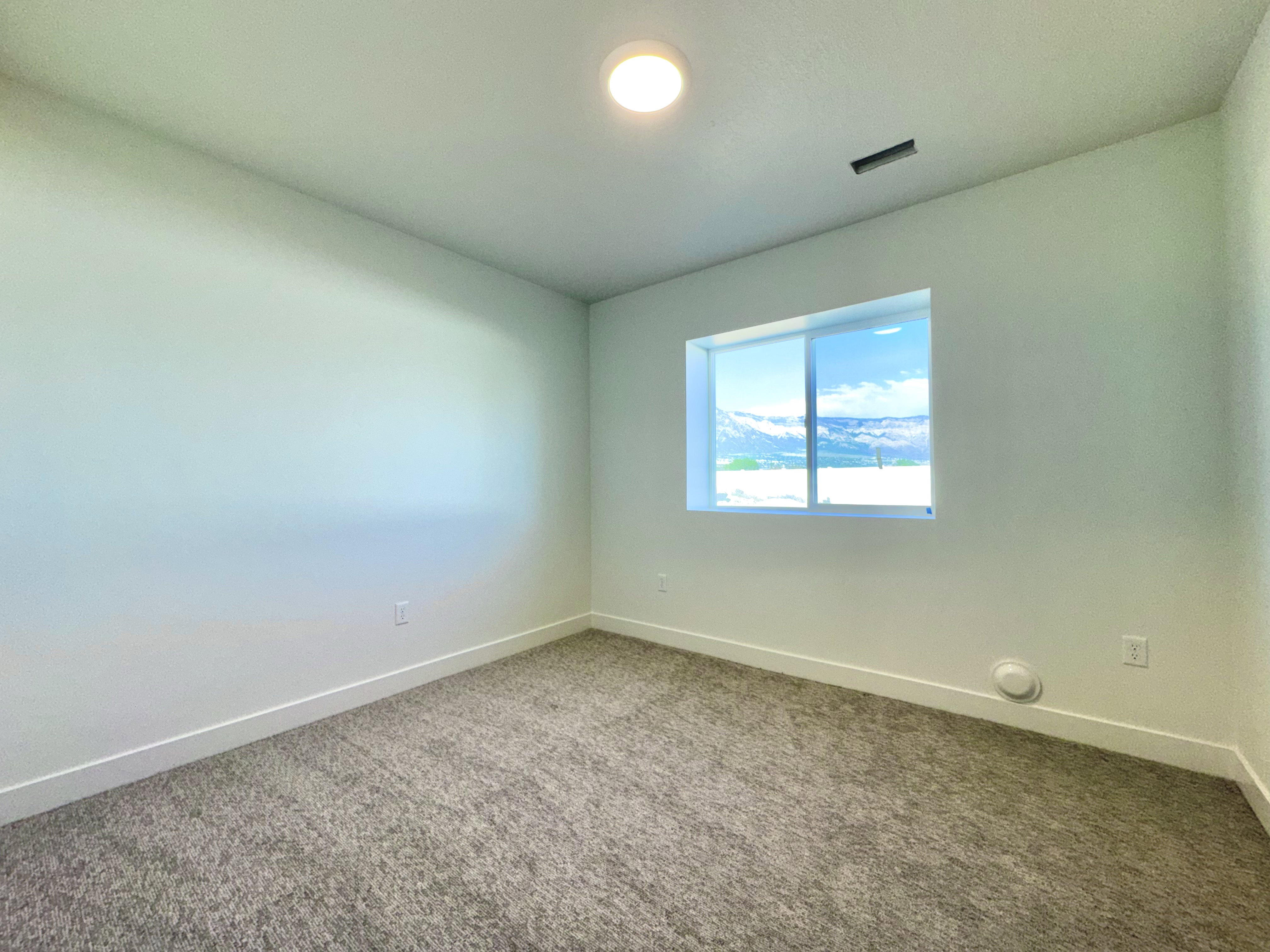 Bright room with light-colored walls and grey textured carpeting