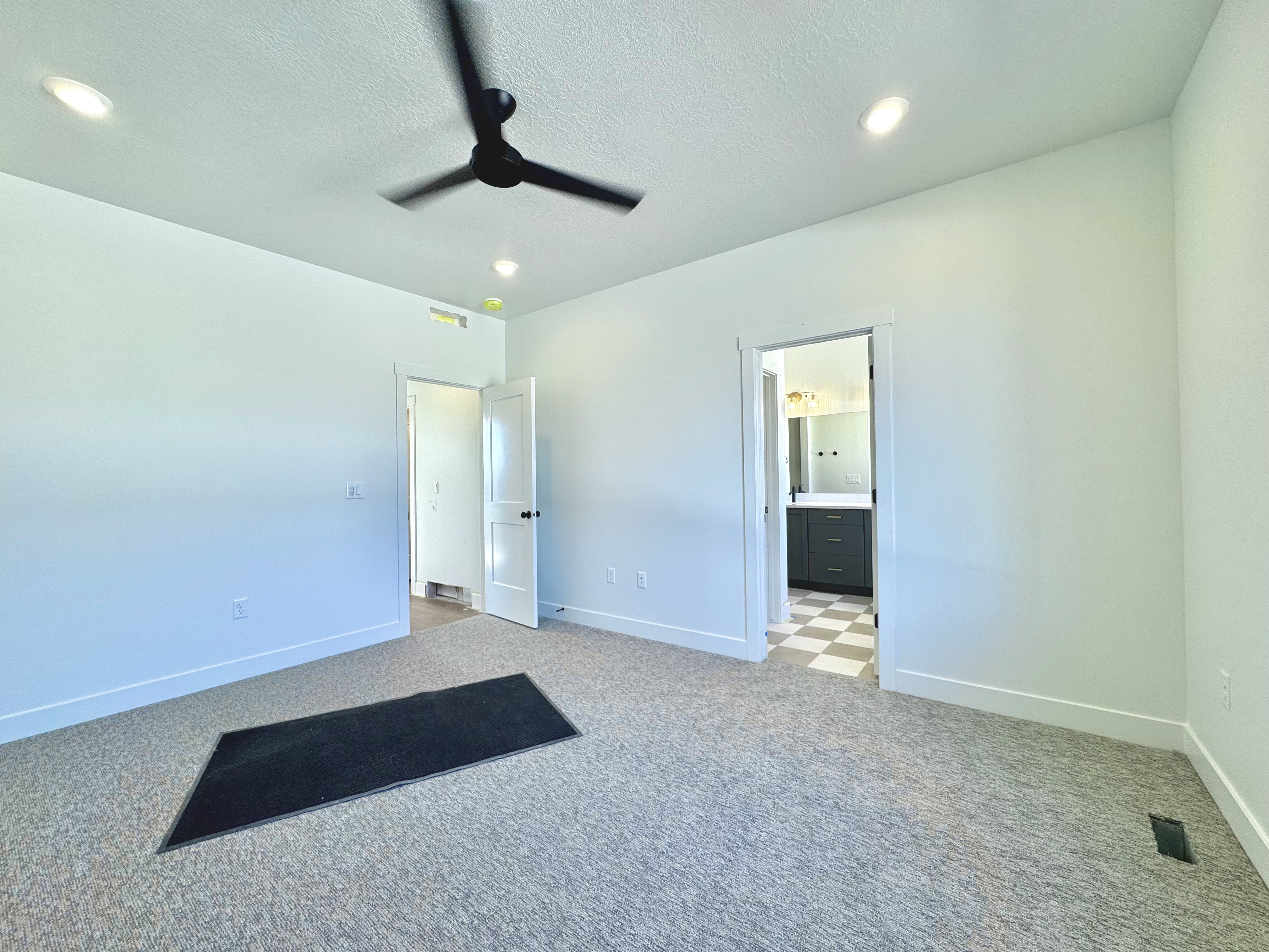 Carpeted room featuring a ceiling fan, recessed lighting, and a white trim package