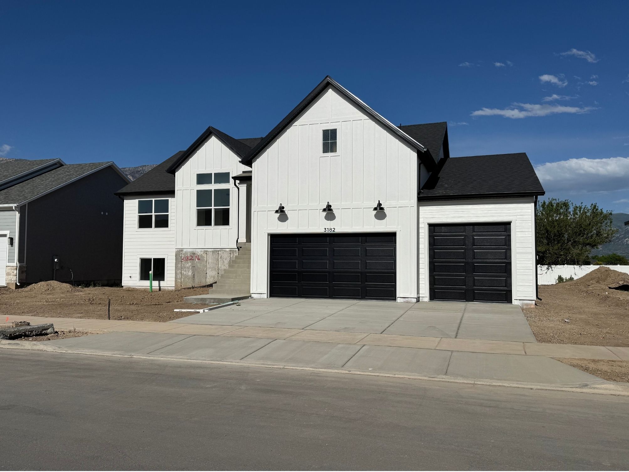 Modern farmhouse exterior with white vertical siding and black-framed windows