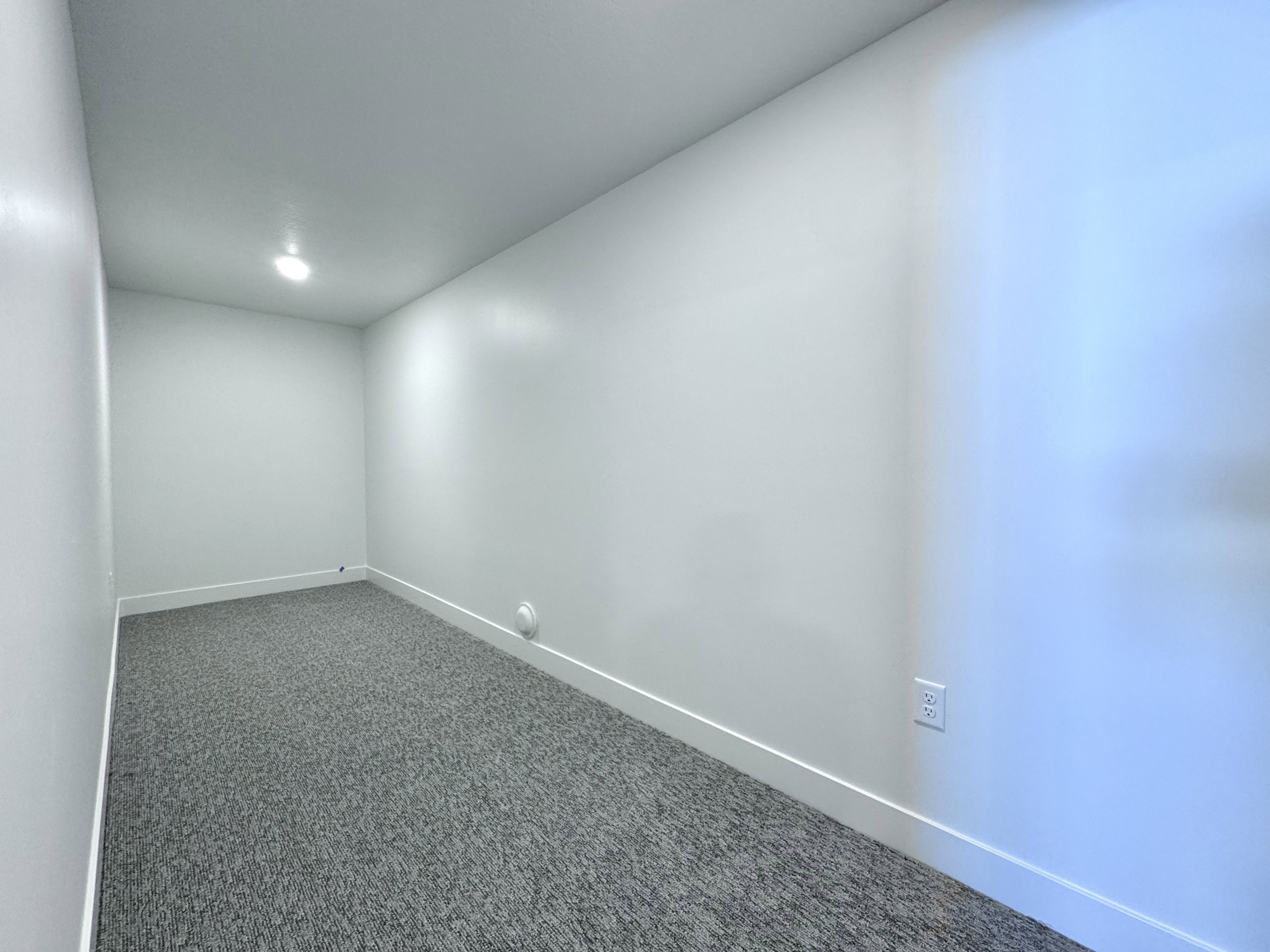 Carpeted interior space featuring white walls and a recessed ceiling light
