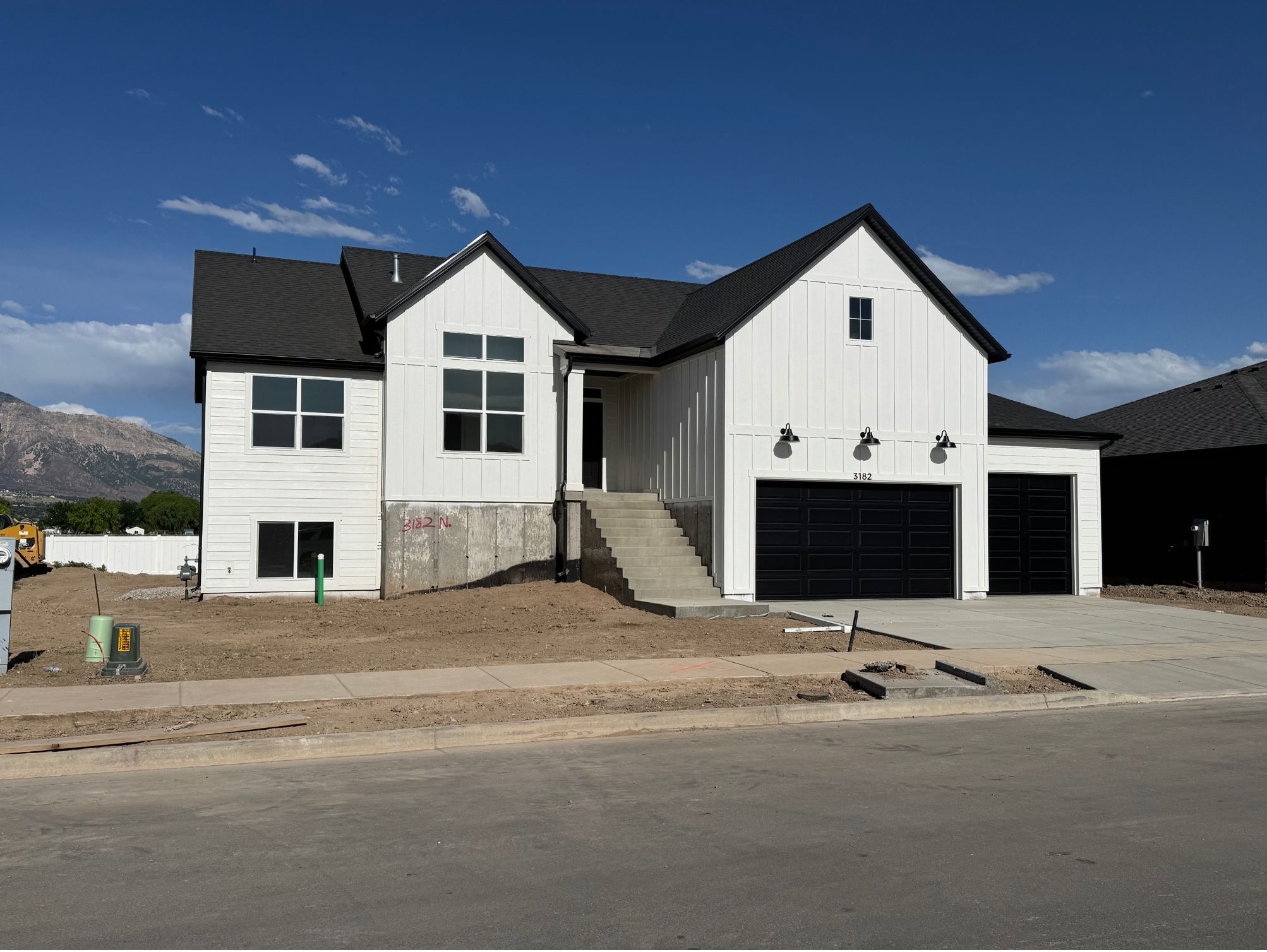 Modern farmhouse-style residence with white vertical siding and black-framed windows