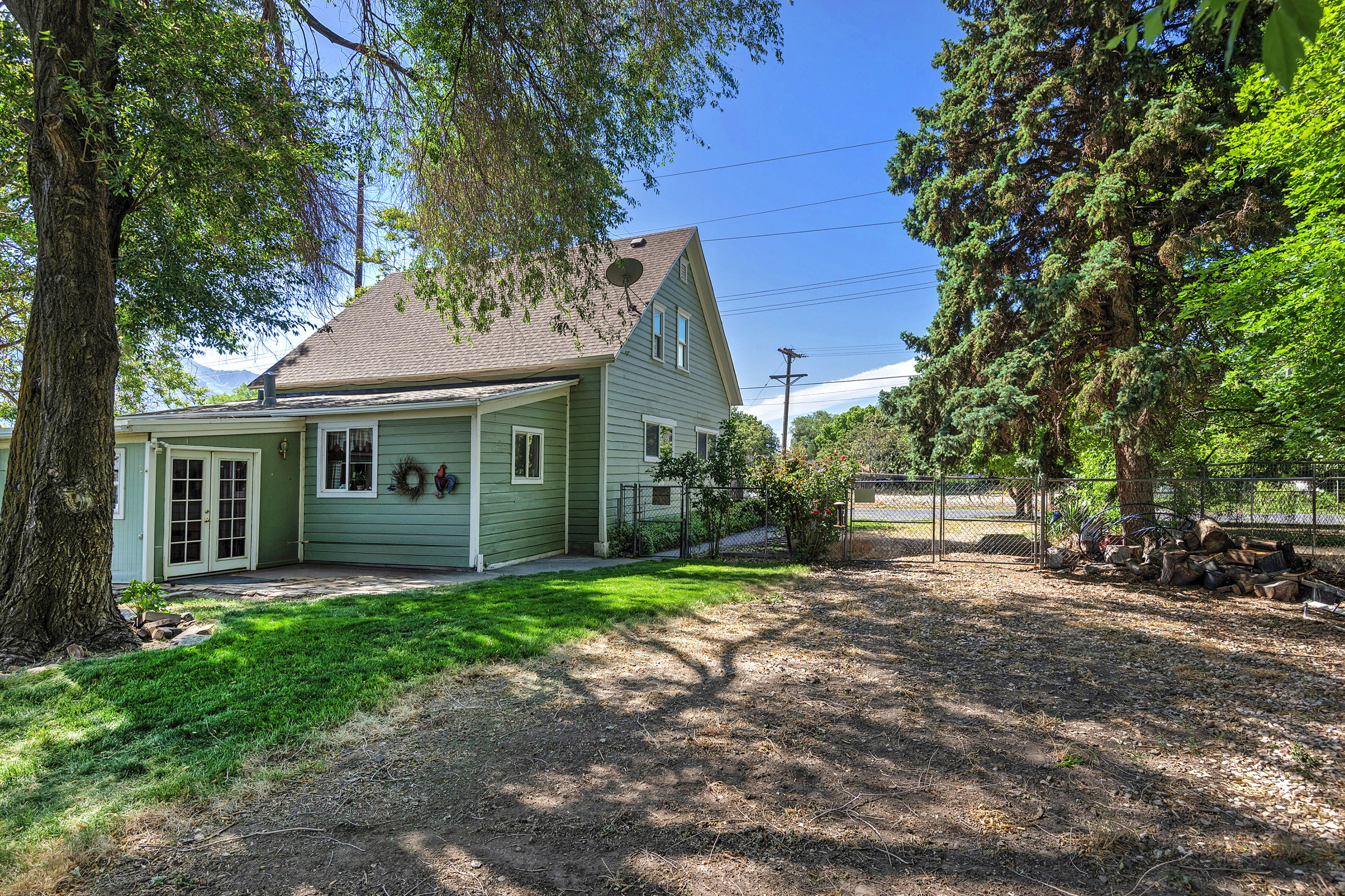 Green siding exterior with a light-toned shingle roof
