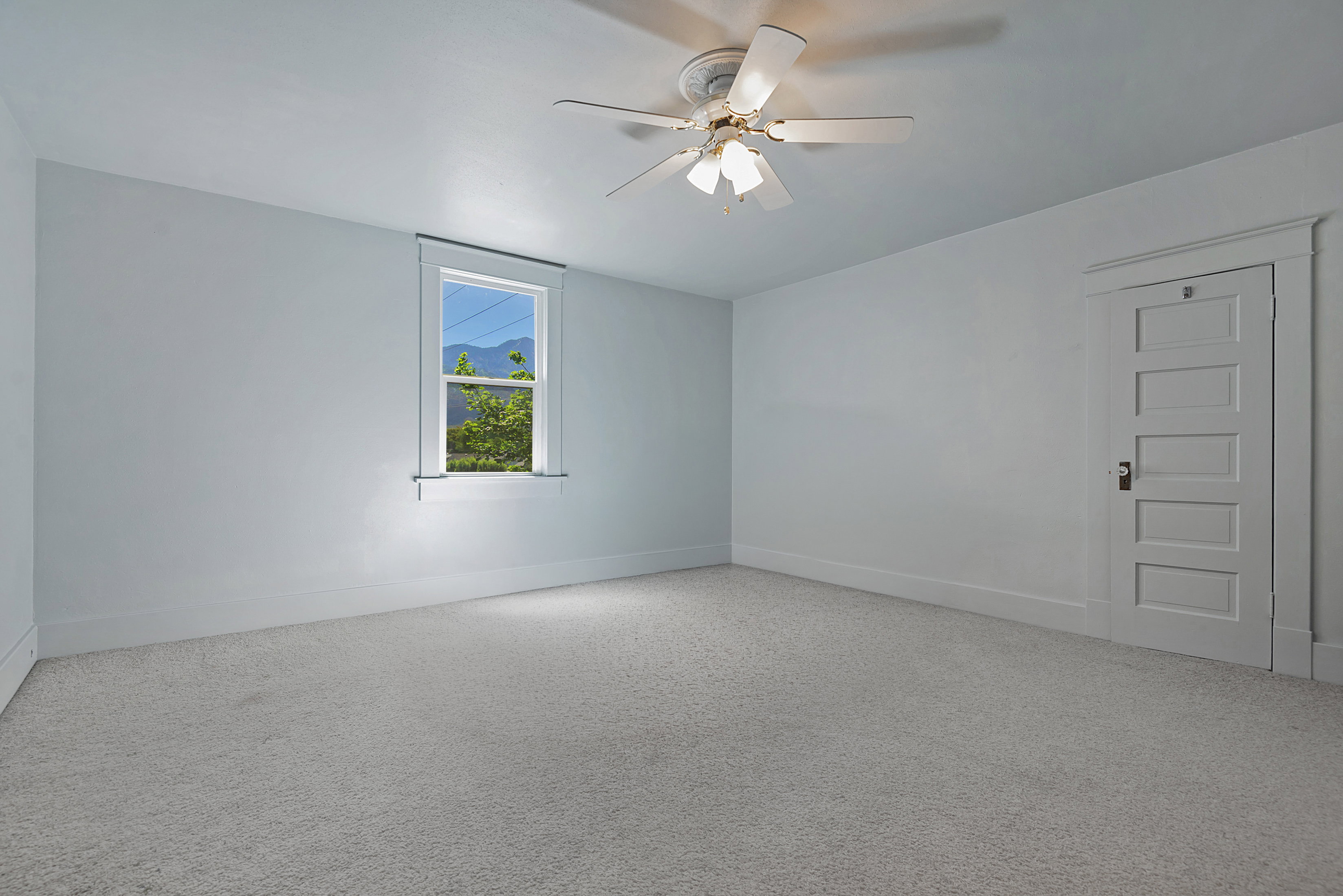 Spacious room featuring light-colored walls and soft carpeting