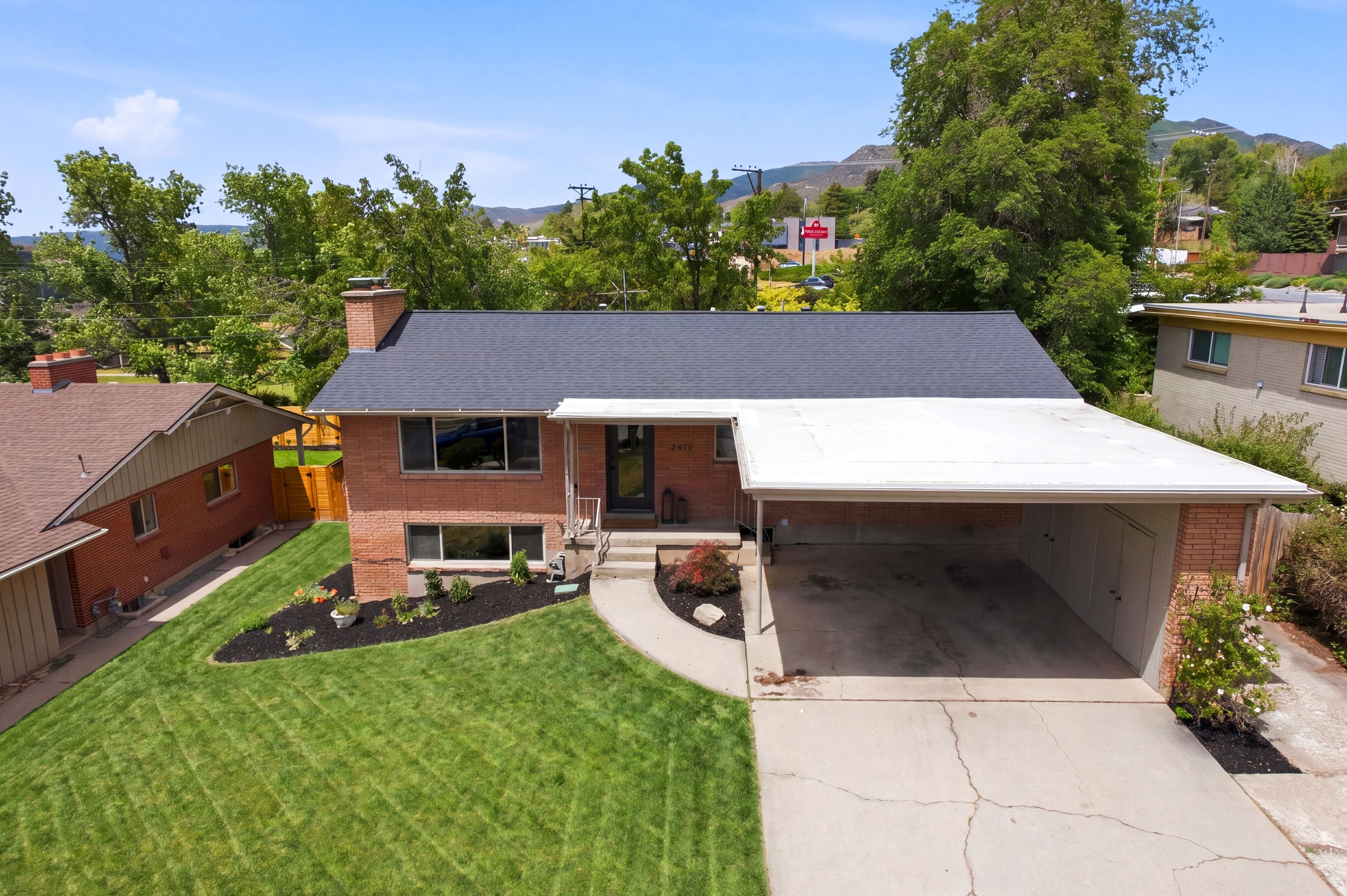 Brick exterior with a dark shingle roof and a covered carport
