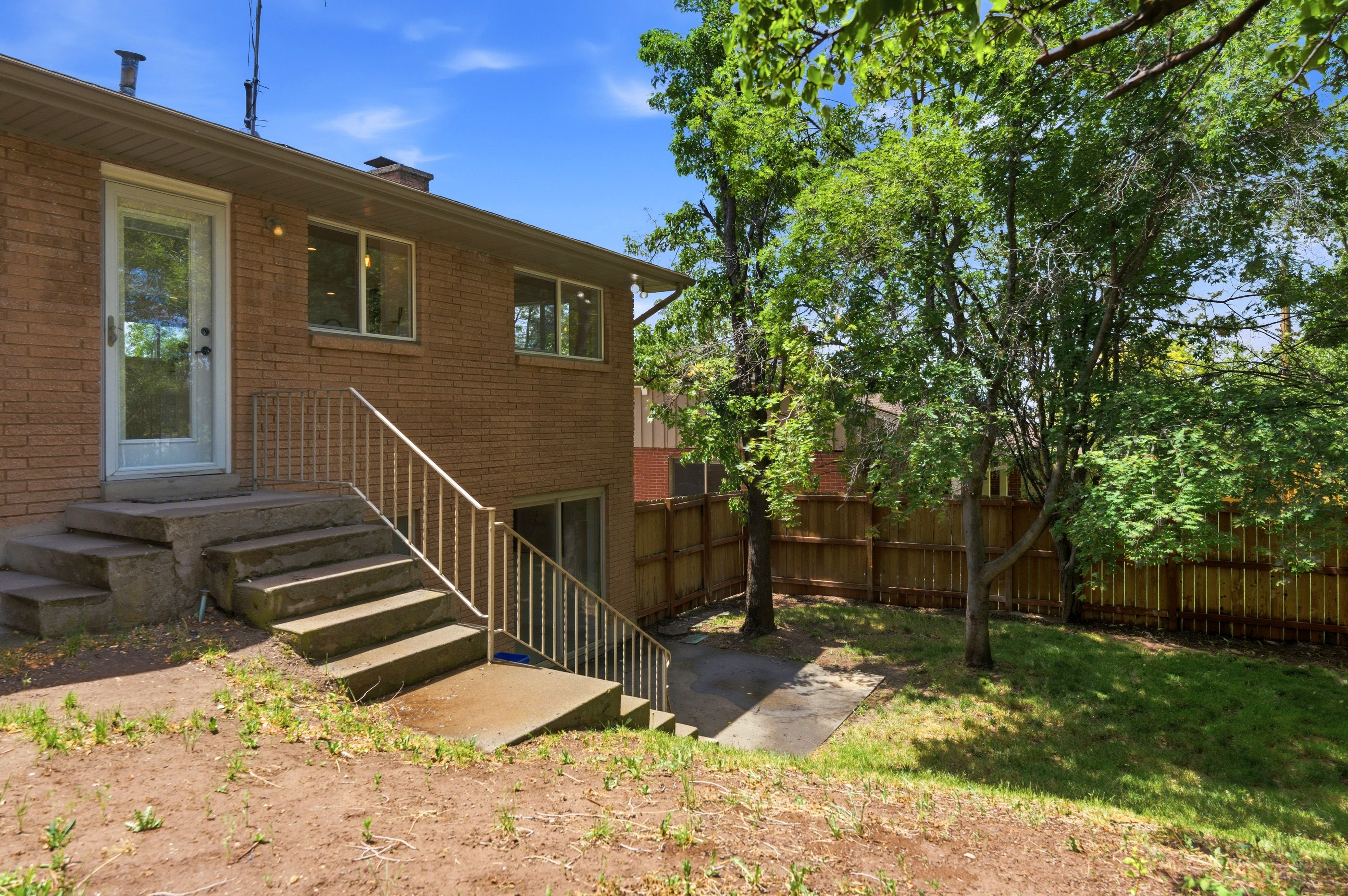 Brick exterior featuring a full-light storm door and multiple windows providing natural light