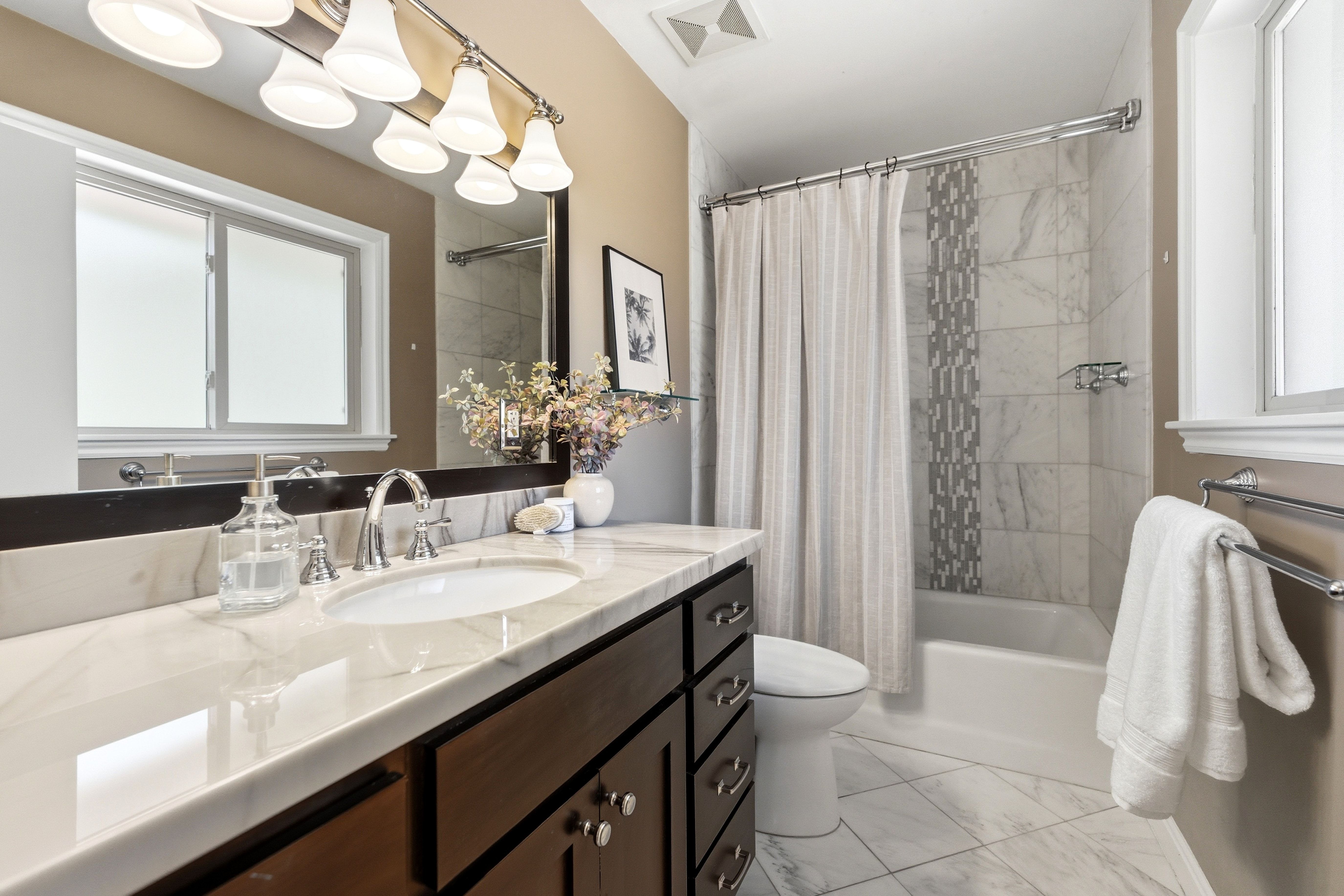 Bathroom featuring a dark wood-finish vanity with a white countertop and undermount sink