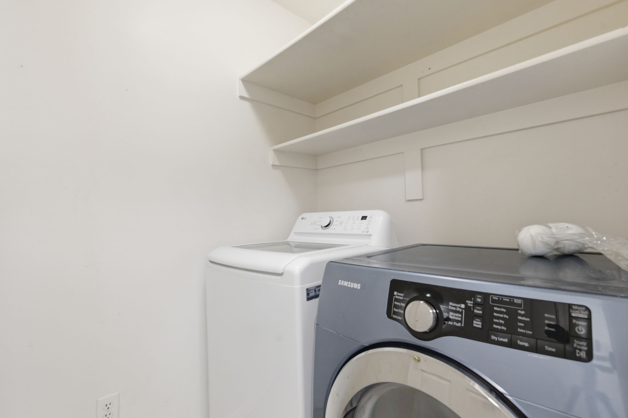 Dedicated laundry area featuring white walls and built-in shelving