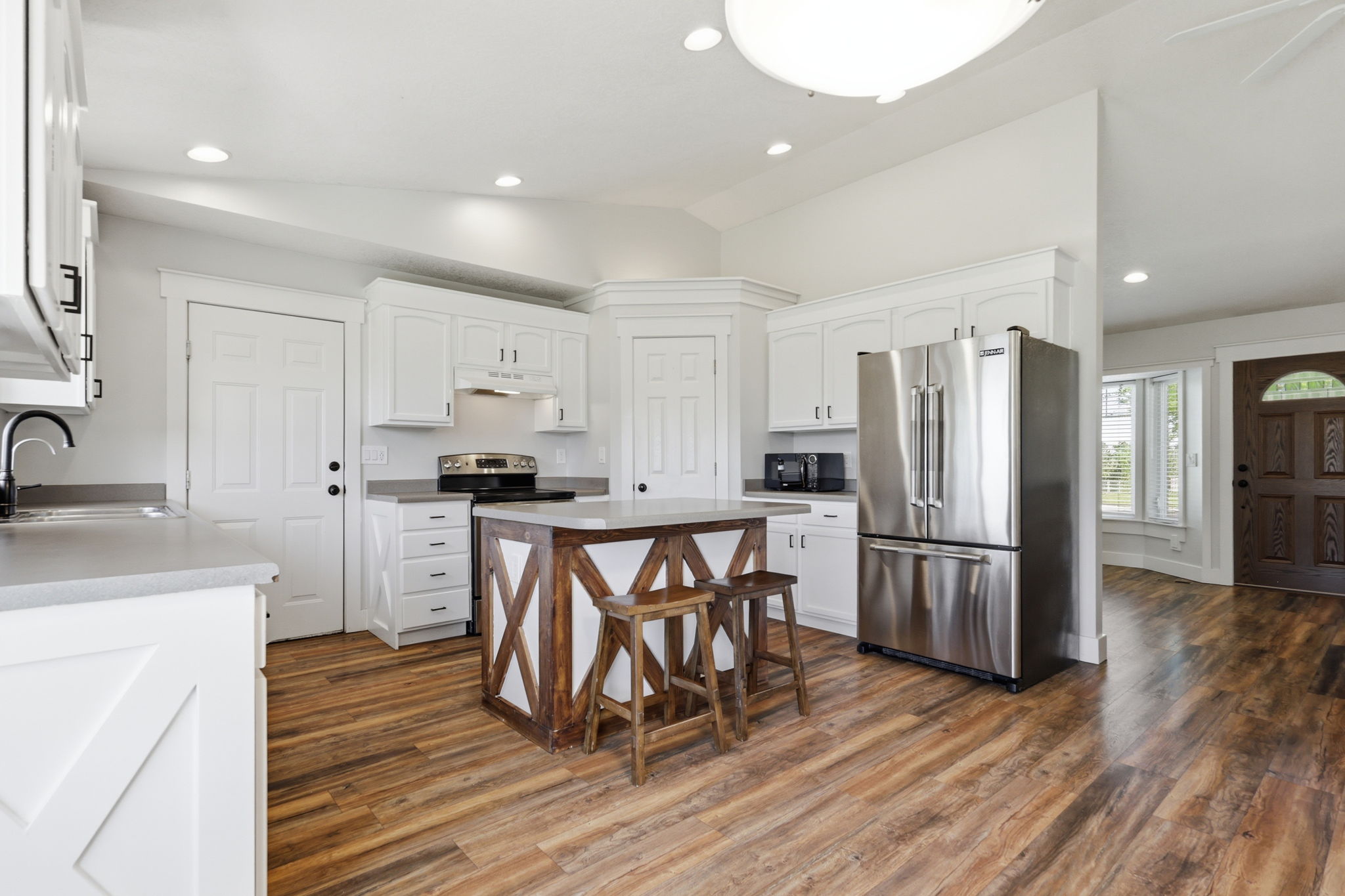 Kitchen featuring white cabinetry, stainless steel appliances, a wood-finish island, wood-finish flooring, and recessed lighting