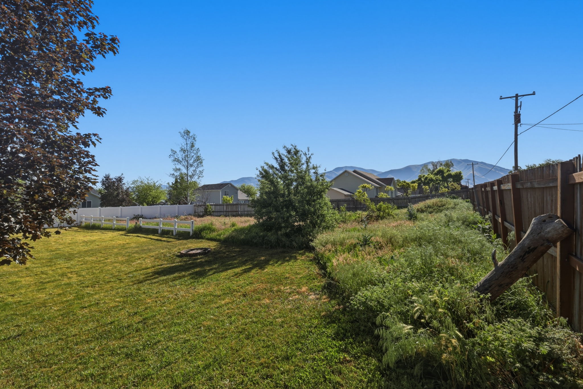 Expansive green lawn area with white picket fencing