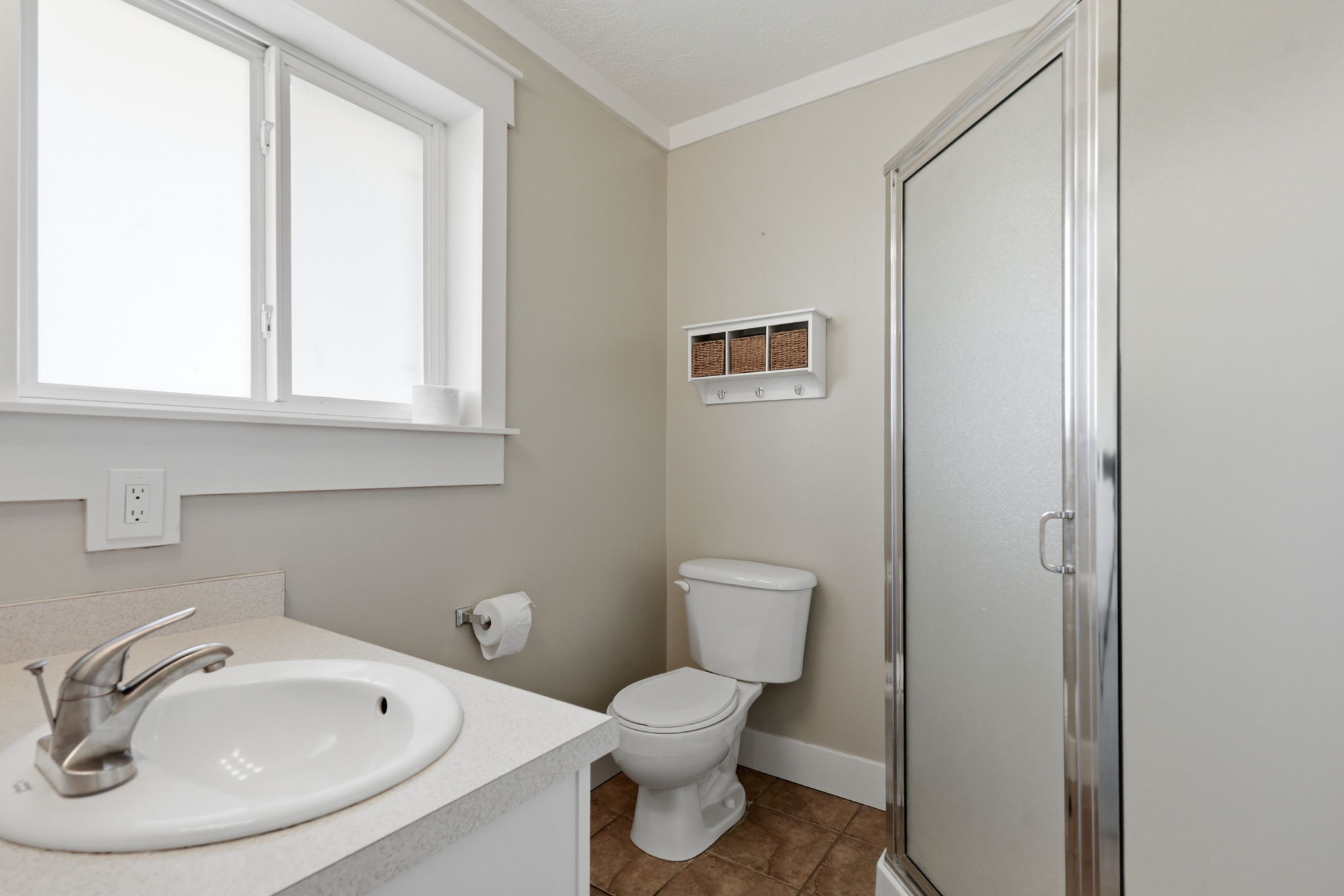 Bathroom featuring a white vanity with an oval sink, brushed nickel faucet, and a large window