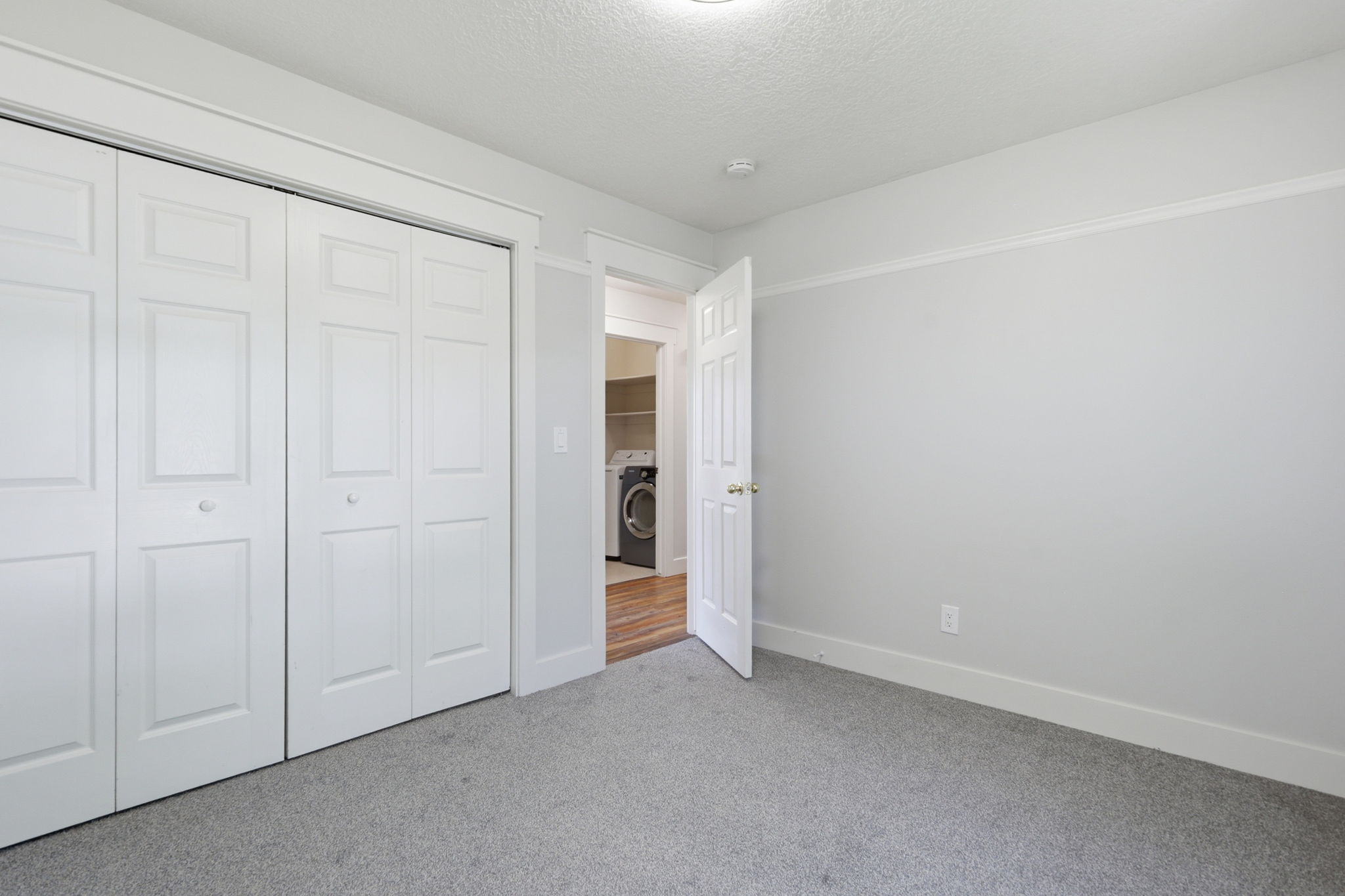 Room featuring neutral gray wall paint, light gray carpeting, and white trim