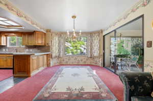 Dining area with a bay window, chandelier, and direct access to an outdoor patio via sliding glass doors