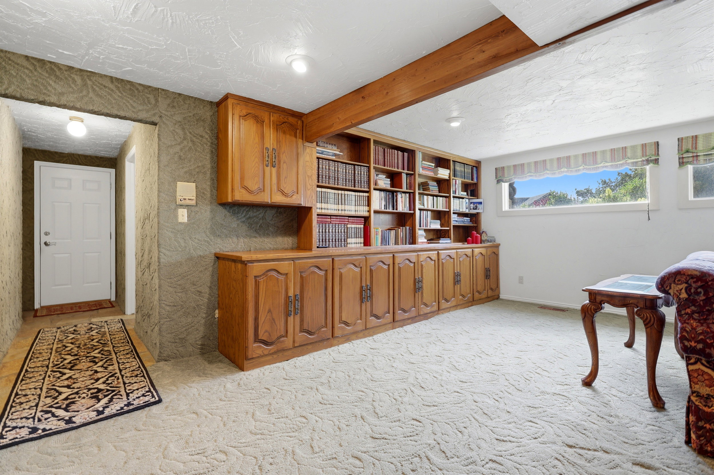 Integrated wood-finish cabinetry and shelving unit with brass hardware