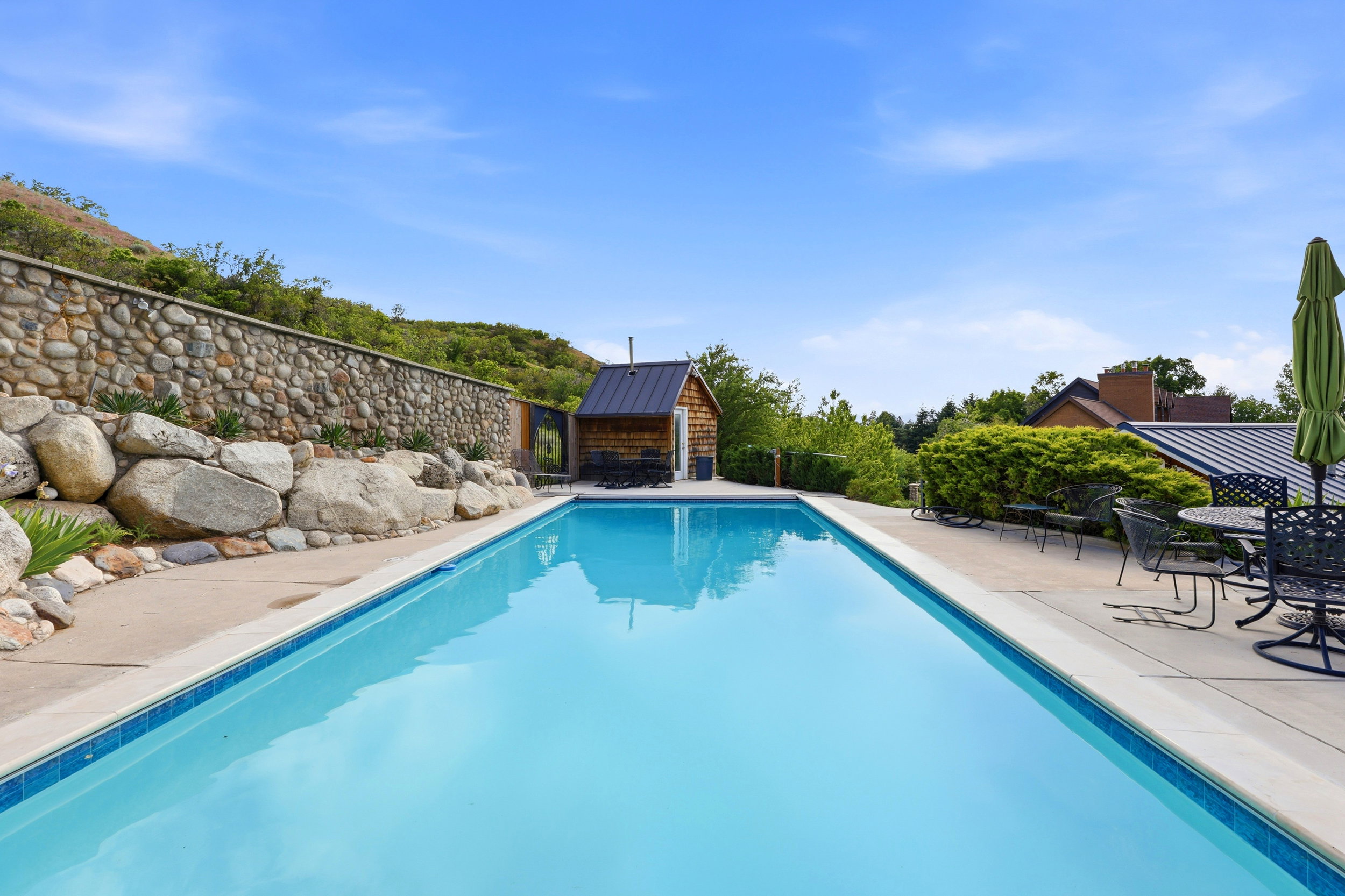 Rectangular swimming pool featuring a tiled edge and concrete surround