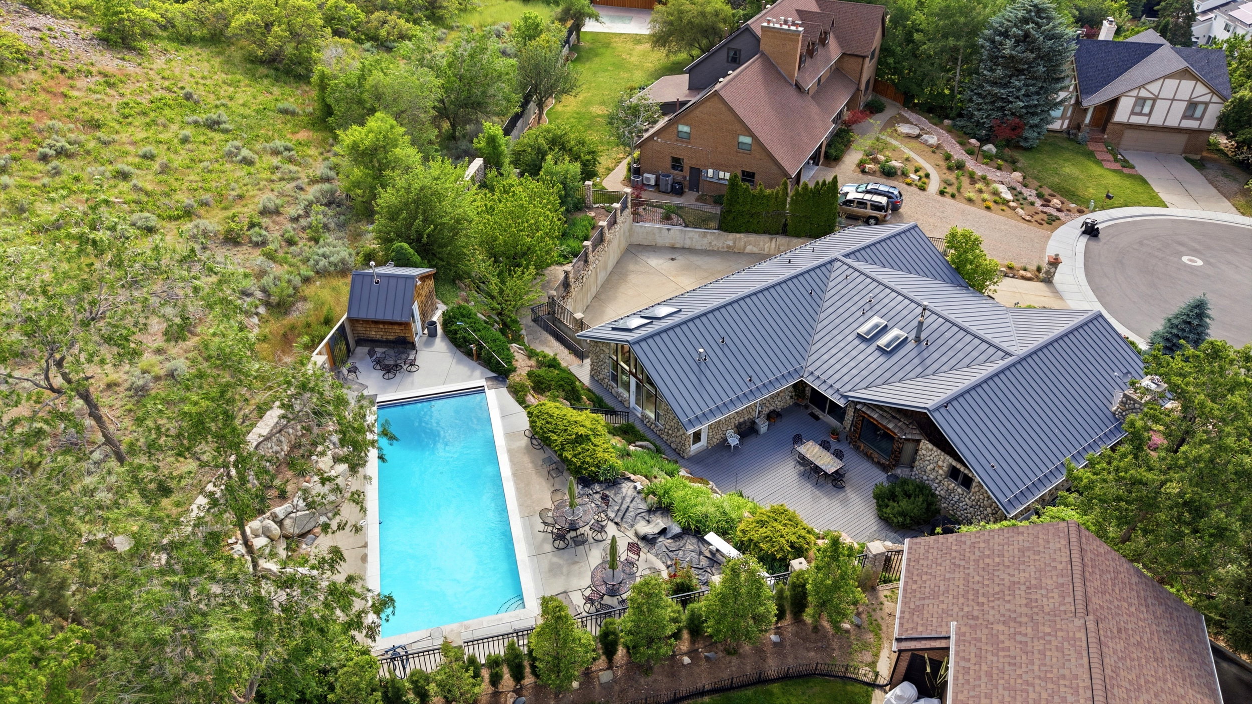 Contemporary stone-clad residence featuring a metal roof and multiple skylights