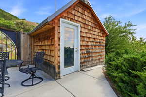 Cedar shake siding structure with a white-framed glass paneled door and metal roof