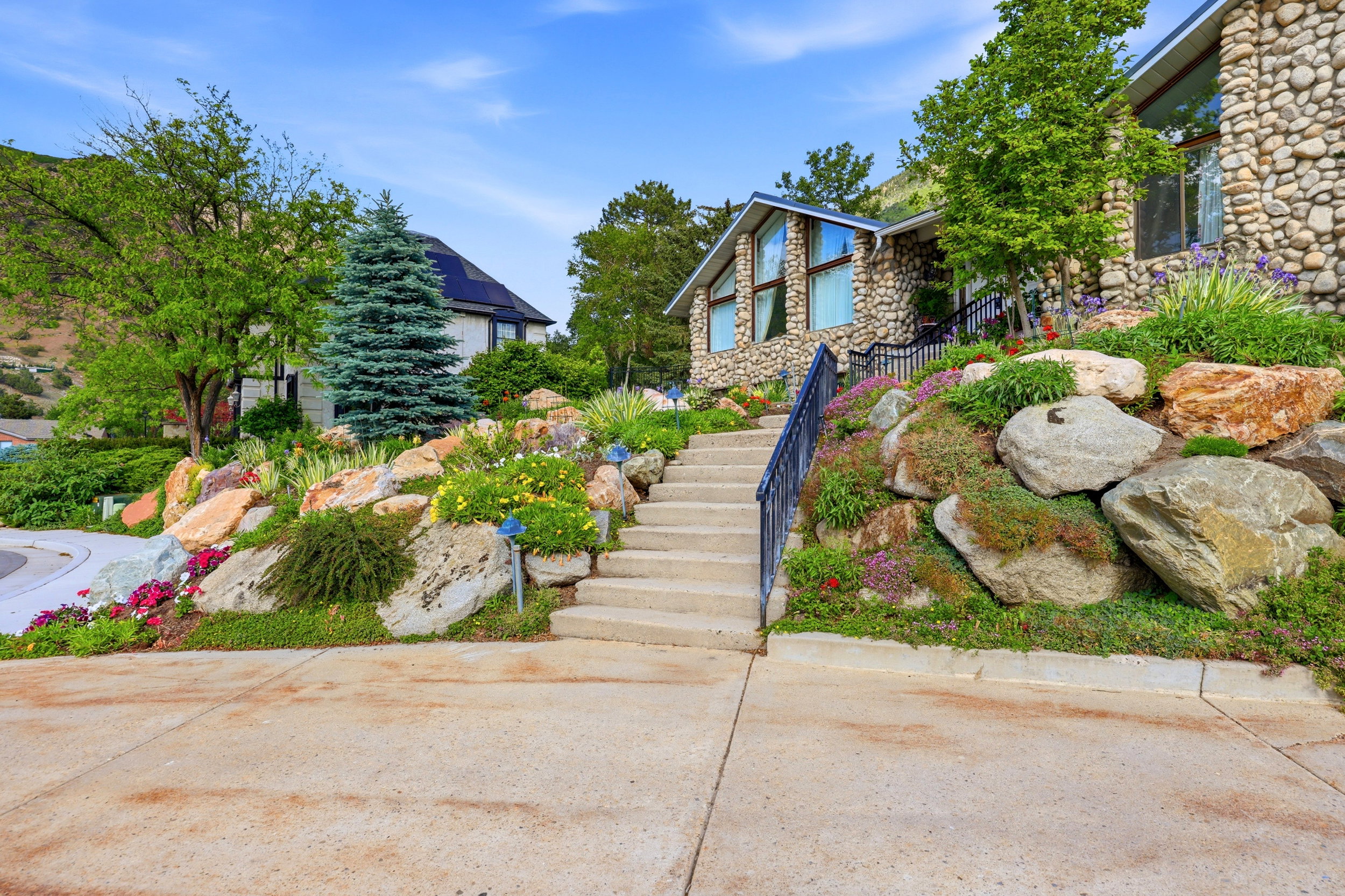 Stone-clad exterior featuring a tiered landscape design