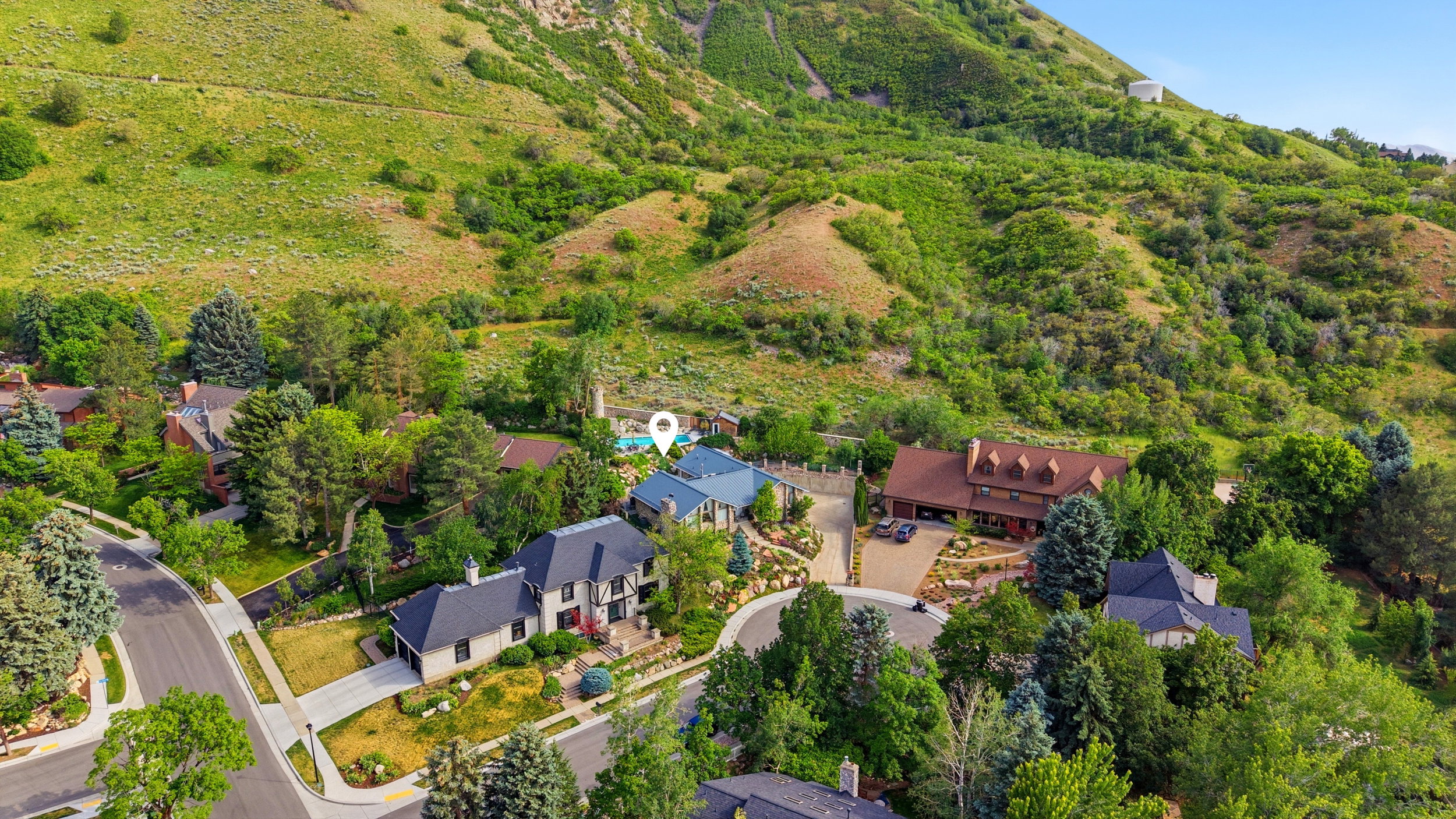 Expansive property featuring a multi-level residence with a blue roof, situated on a terraced lot